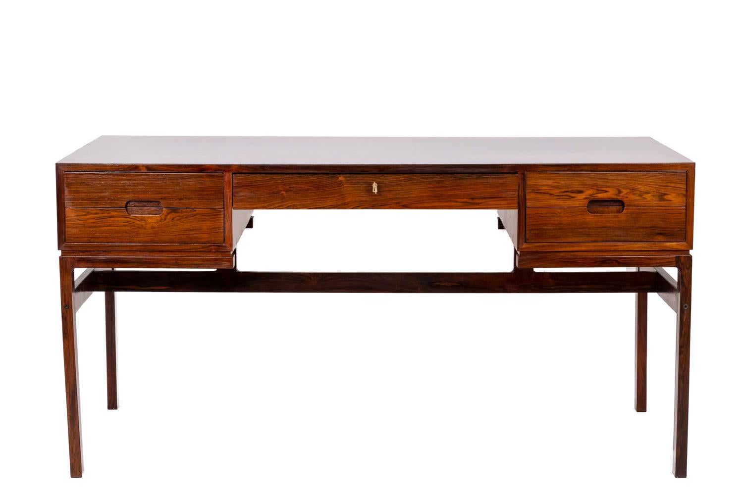 Arne Wahl Iversen, attributed to.
Danish control, edited by.

Desk in rosewood, opening with five drawers in front, two niches in the back. H-shaped legs connected by a central spacer. Assembly of drawers in straight tails. Rectangular handles.