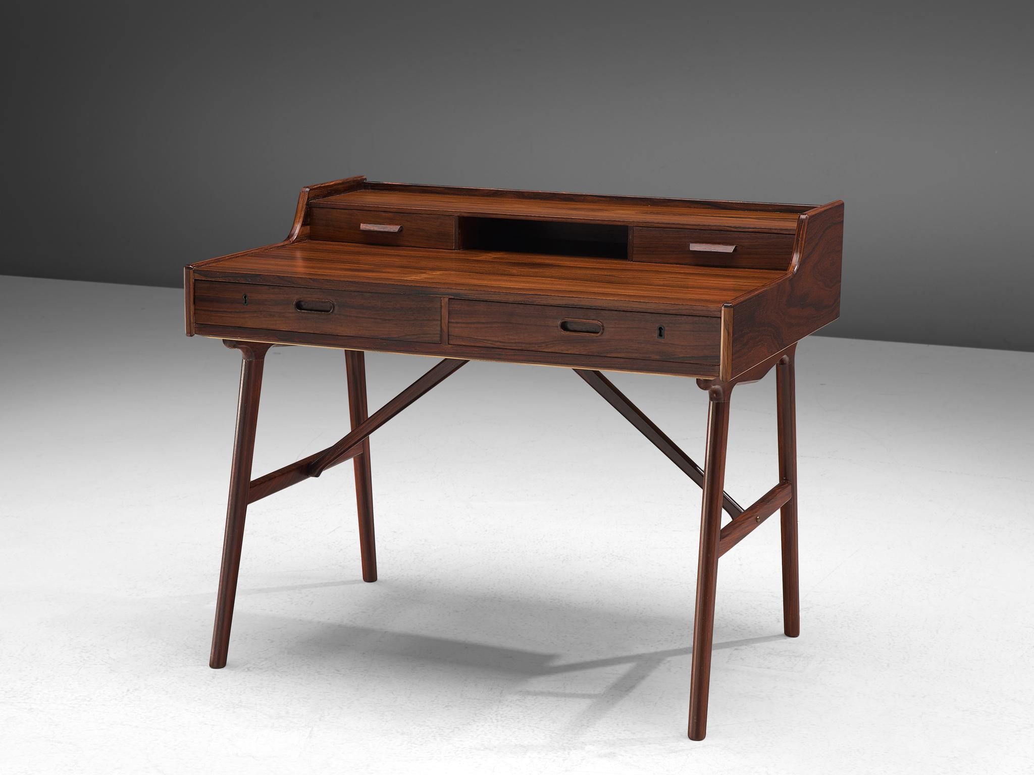 Arne Wahl Iversen for Vinde Møbelfabrik, Desk model 65, rosewood, Denmark, circa 1961.

Refined and excellent writing table by Danish designer Arne Wahl Iversen. This small writing table has a beautiful open look due the high tapered legs. The table