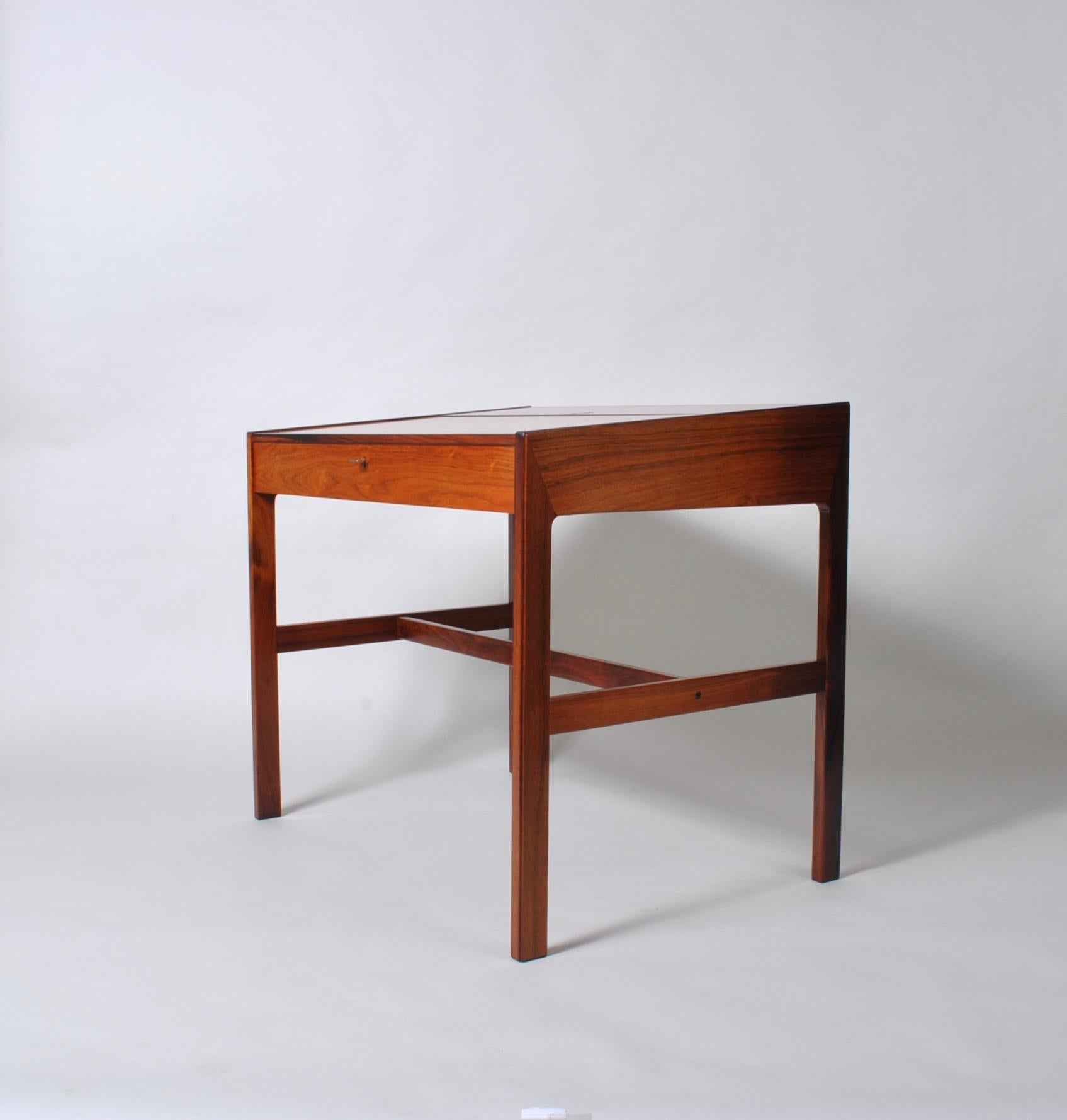 Superb Danish rosewood modernist desk or vanity by Arne Wahl Iversen for Vinde Mobelfabrik, Denmark, circa 1960.
Lovely rosewood construction with a flip top hatch revealing a multi compartment interior and mirror. Lockable front drawer. Wonderful