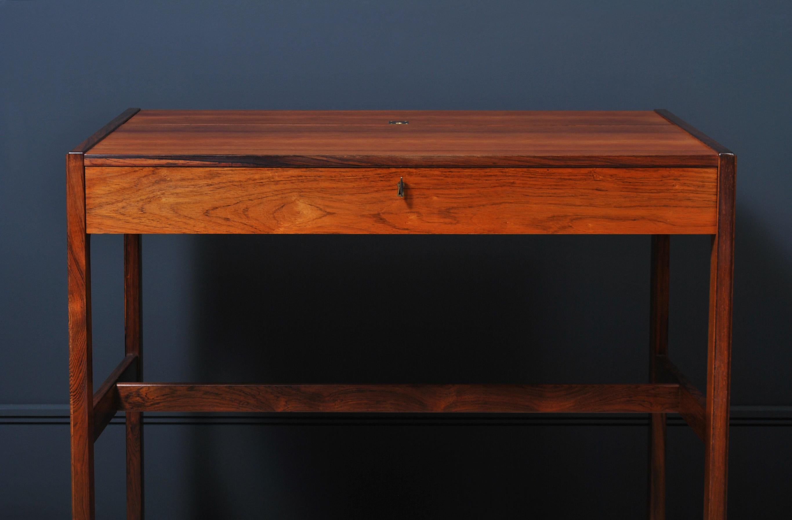 Superb Danish rosewood modernist desk by Arne Wahl Iversen for Vinde Mobelfabrik, Denmark, circa 1960. Very rare model 82.
Lovely rosewood construction with a flip top hatch revealing a multi compartment interior and mirror. Lockable front drawer