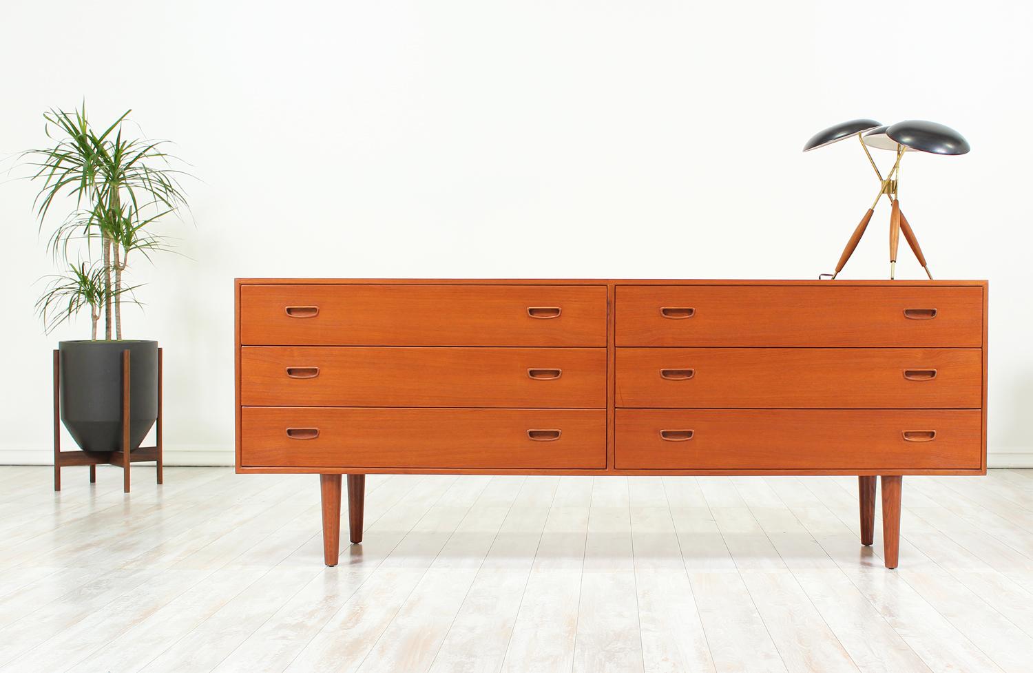 Elegant dresser designed by Arne Wahl Iversen for Vinde Møbelfabrik in Denmark circa 1950’s. This practical dresser is beautifully crafted in teak wood featuring plentiful storage options with recessed carved pulls and six dovetailed drawers. The