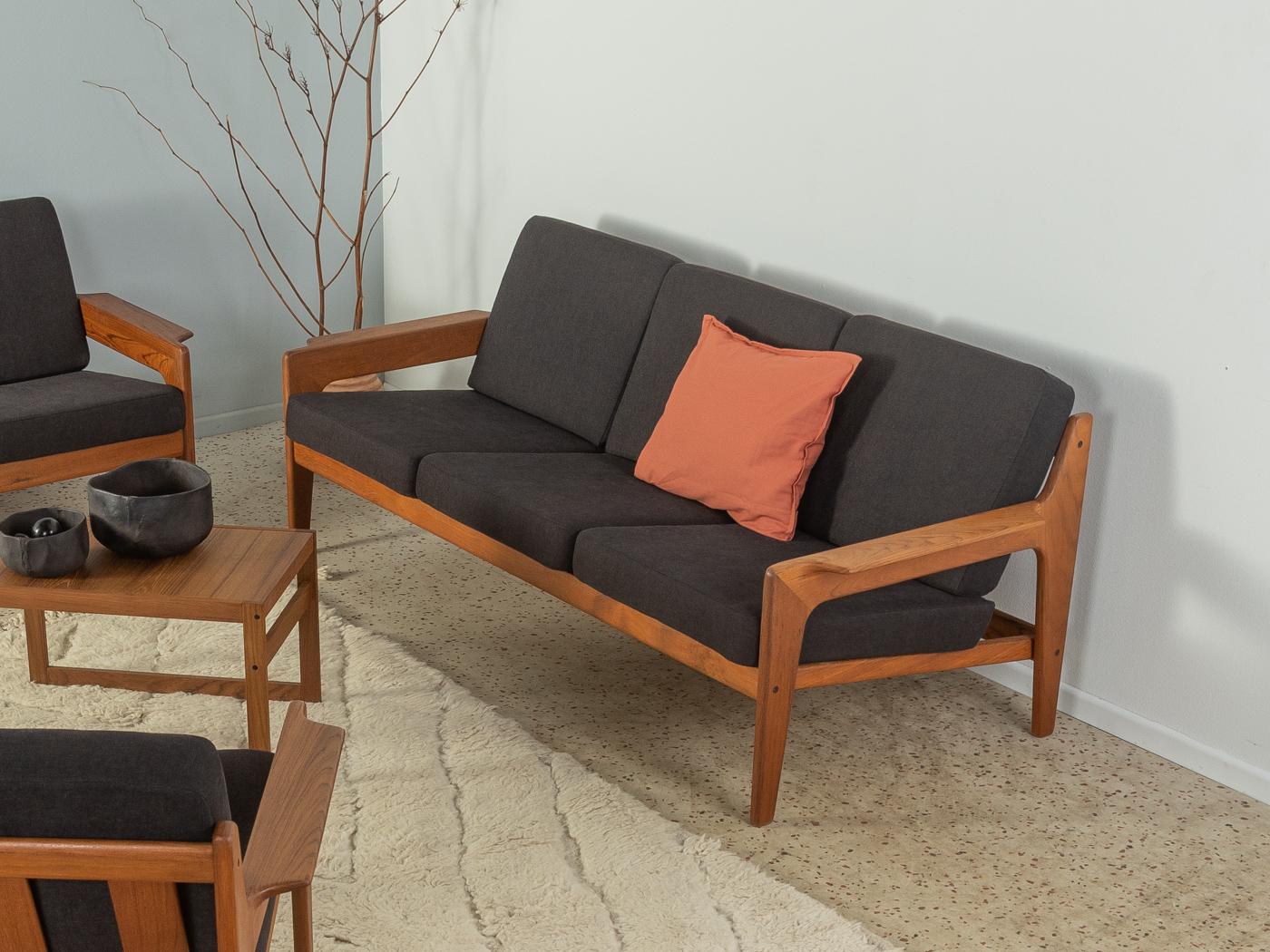 Klassisches 3-Sitzer-Sofa in Teakholz aus den 1960er Jahren von Arne Wahl Iversen für Komfort. Das Sofa wurde neu gepolstert und mit einem hochwertigen Stoff in Schwarz bezogen.

Qualitätsmerkmale:
    vollendetes Design: perfekte Proportionen und