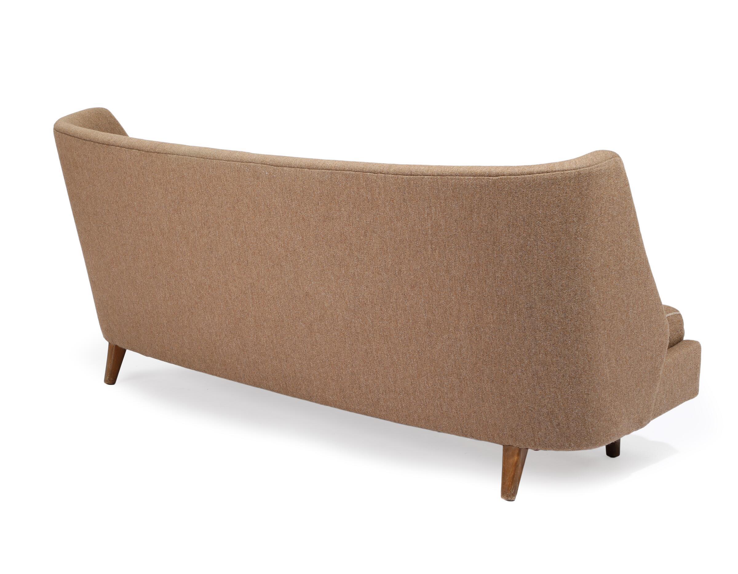 Rare and vey cool three-seater sofa in slightly curved shape with stained beech legs designed by Arne Wahl Iversen in the mid-1950s and made by Hans Hansen sometime in the early 1970's. The design bears a strong resemblance to Iversen's 