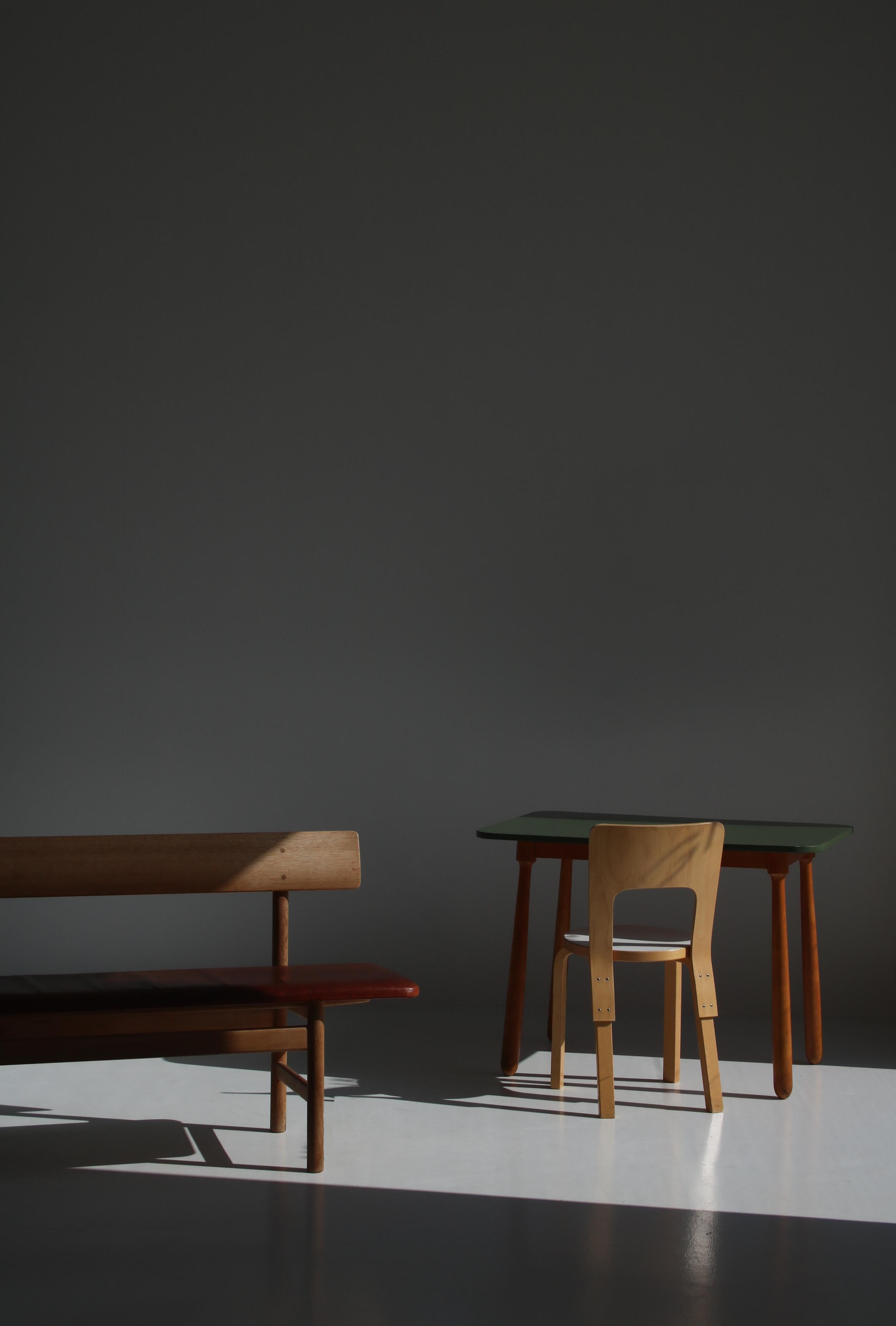 Früher und wichtiger Schreibtisch, der dem dänischen Designer Arnold Madsen zugeschrieben wird. Die keulenförmigen Beine sind aus massiven, handgedrechselten Buchenholzstücken gefertigt und ähneln den Beinen von Madsens berühmtem 