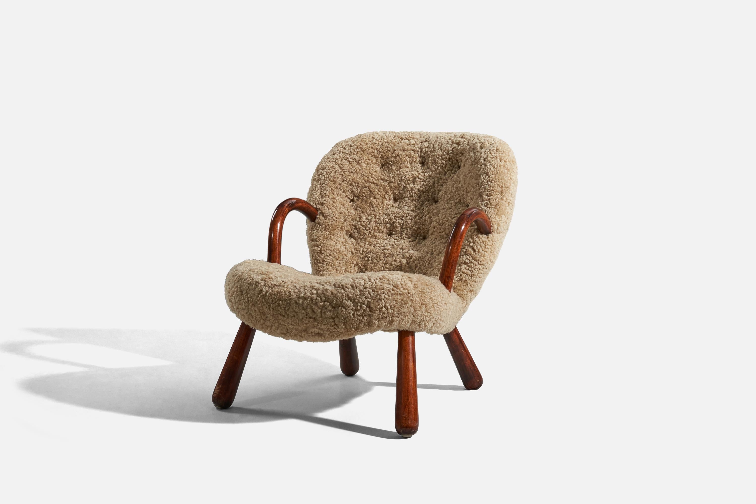 A sheepskin and wood lounge chair designed by Arnold Madsen and produced in Denmark, 1950s.