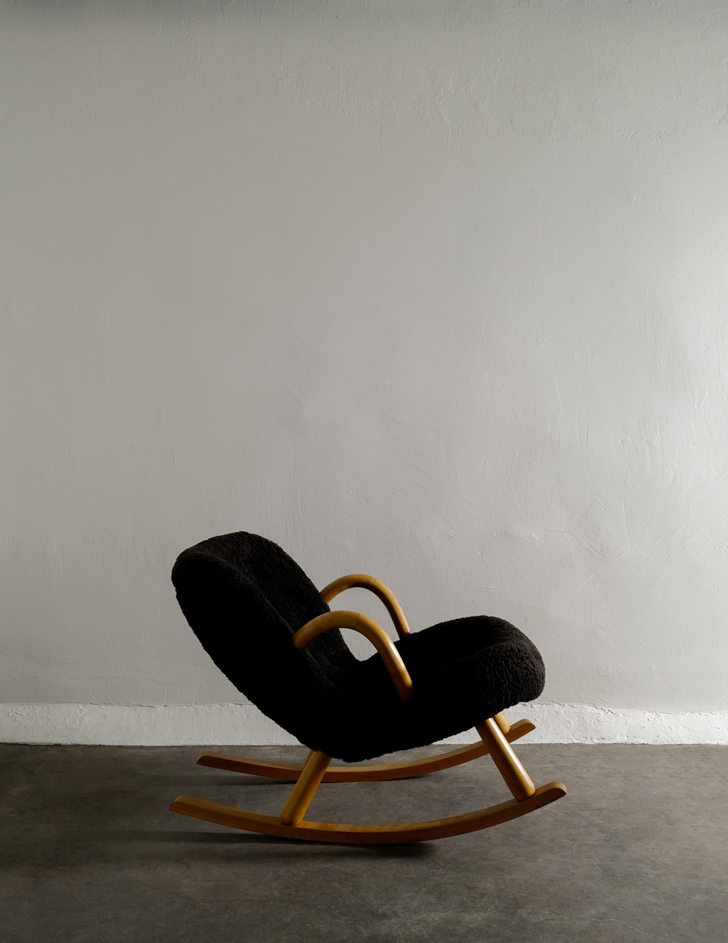 Very rare Scandinavian modern / mid-century rocking clam chair designed by Arnold Madsen and produced by Nordisk Staal / Møbel Central in Denmark during the 1940s. The chair has been professionally restored and upholstered with dark brown sheepskin.