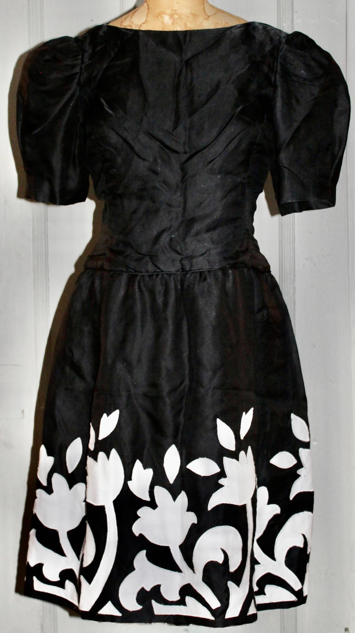 An Arnold Scassi Boutique black silk cocktail dress, appliquéd with white Matisse influenced tulip flower cutouts. Lined with horsehair and silk lining. Invisible zipper up the back. Short puffy cap sleeves.