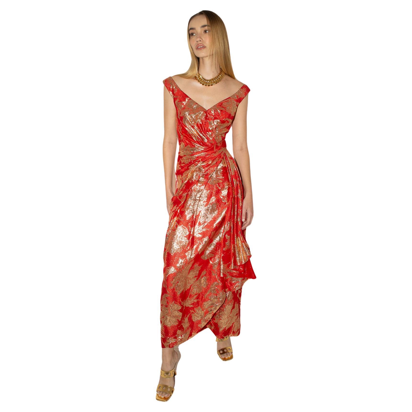 Exemple opulent de la couture américaine du milieu du siècle, cette robe d'Arnold Scaasi des années 1960 est réalisée dans un riche brocart métallique rouge et or, taillée dans une silhouette sculpturale à épaules dénudées qui s'enroule et se drape