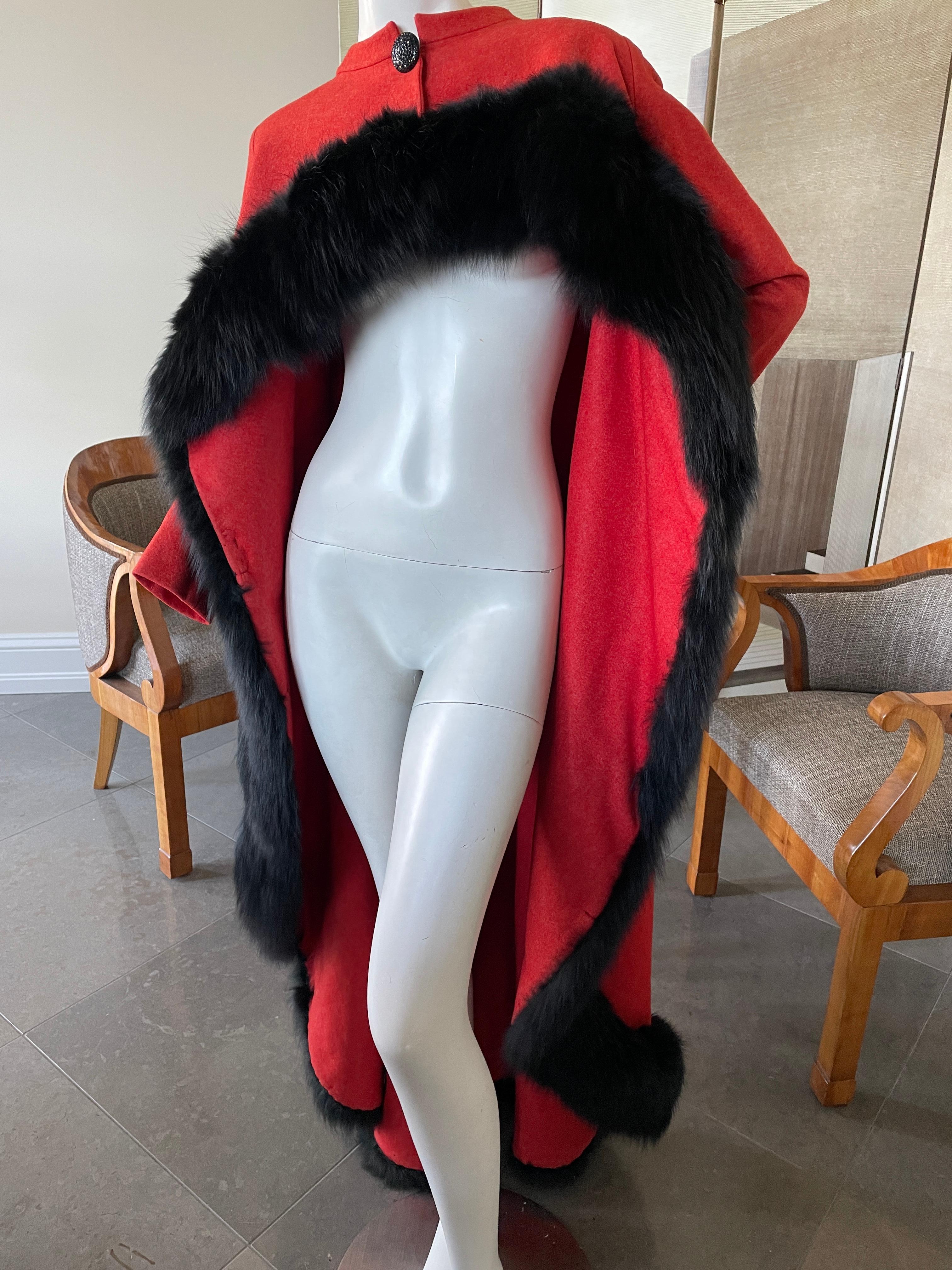 Arnold Scaasi 1960's Opera Coat with Short Bolero Front and Fox Trim Floor Length Cape.
This is a wonderful piece, in an orange red felt wool. It might have originally been lined.
There is moth damage near the shoulders of both sleeves, see last