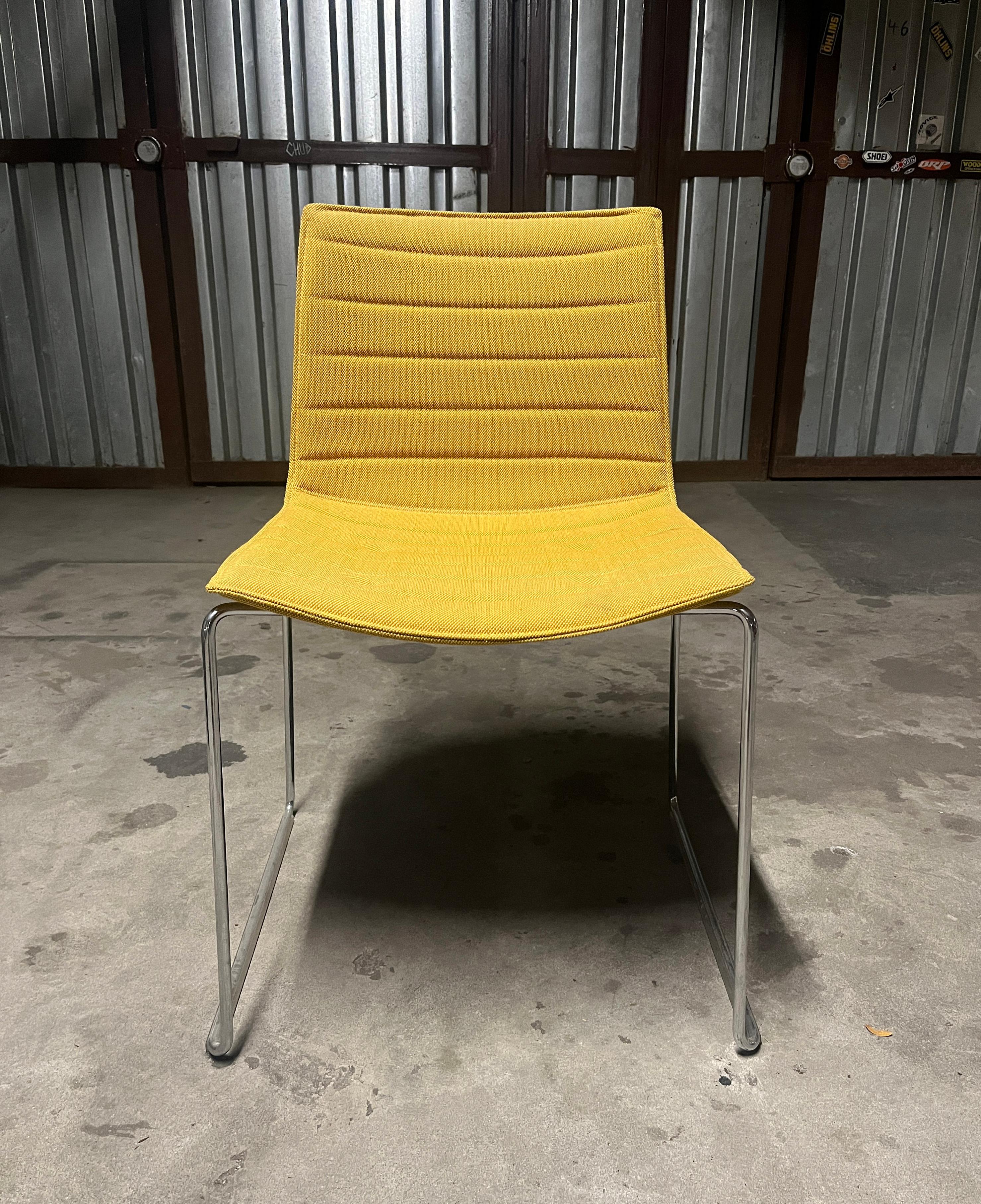 Beautiful set of 8 orange and 1 mustard upholstered stackable dining chairs. The sled chromed steel bases are in great shape contouring the seats for perfect sturdiness. The fun colors would be a great addition to any office, dinning room, or