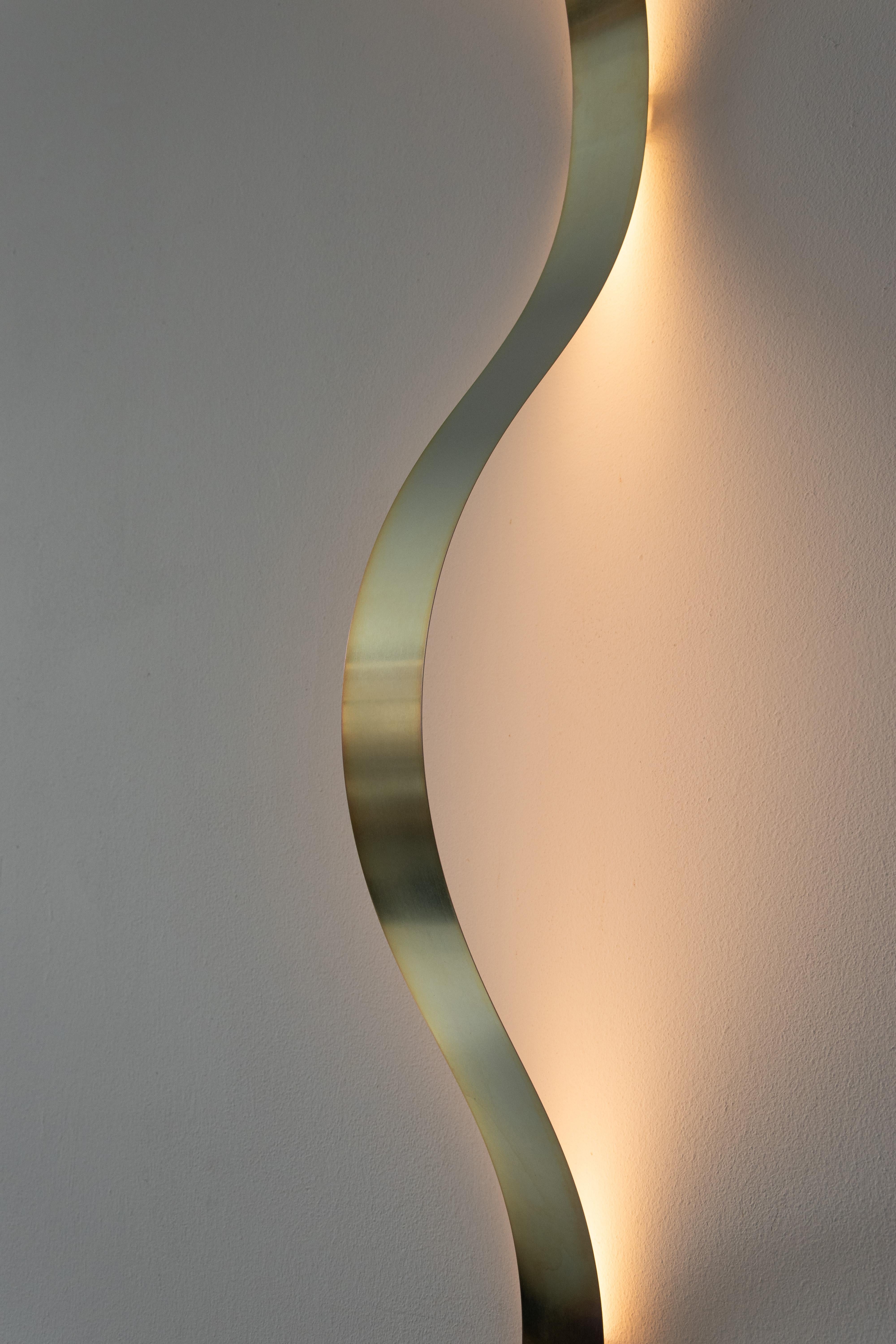 The Sine Lights are made out of powdercoated spring steel strips. By fixing the lamp to the wall or ceiling with small brackets, the wave form appears as a result of the tension in the material.

The LED lighting on the back gives of a pleasant