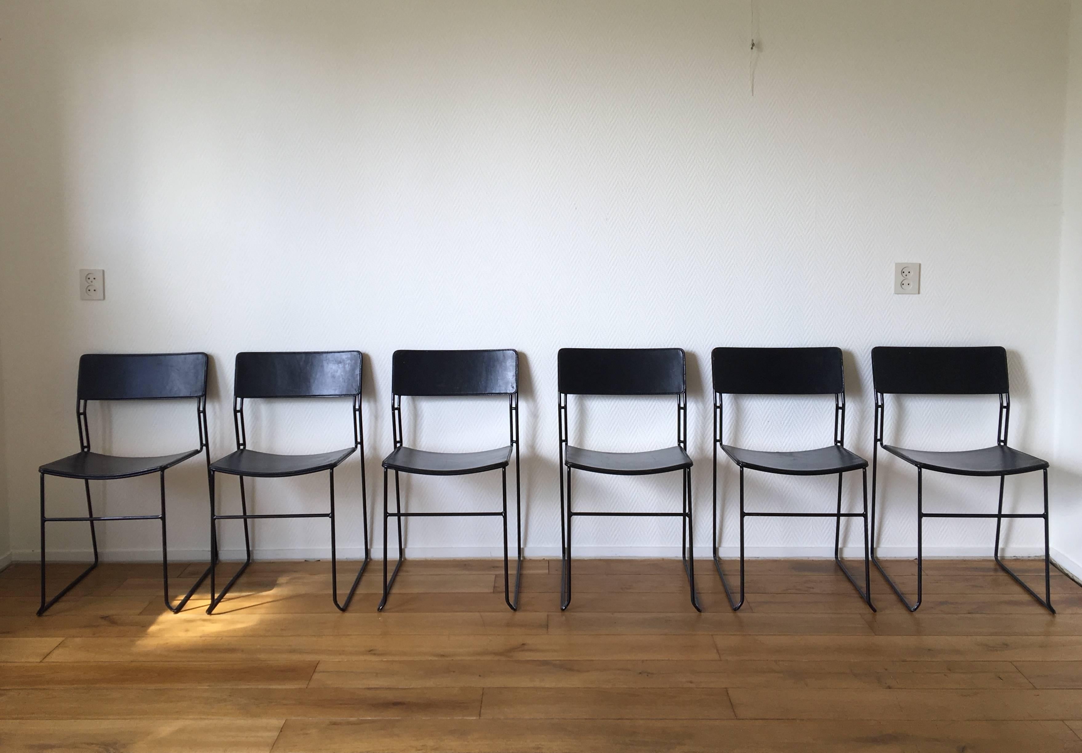 Rare minimalist set of six dining chairs, manufactured by Arrben, Italy. The chairs feature a black enameled heavy metal wire base with thick Black Cuir Leather upholstery. While the chairs are stackable and piled up many times, they show some light
