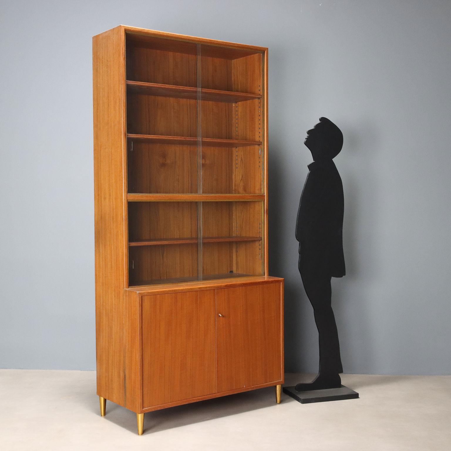 Mobil contenitore con impiallacciatura in larice e particolari in ottone, con vetrina e ante a battente. In buone condizioni generali, presenta qualche sbeccatura sui vetri come visibile in foto.