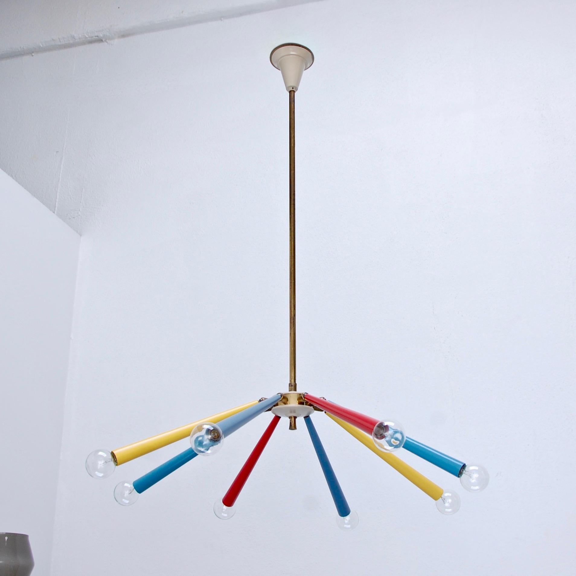 1950s multicolored adjustable sputnik by Arredoluce of Italy. 8 arm sputnik with the capability to adjust the angle of the arms due to joints at the centre hub. Partially restored, original brass finish. 8 E12 candelabra based sockets. Light bulbs