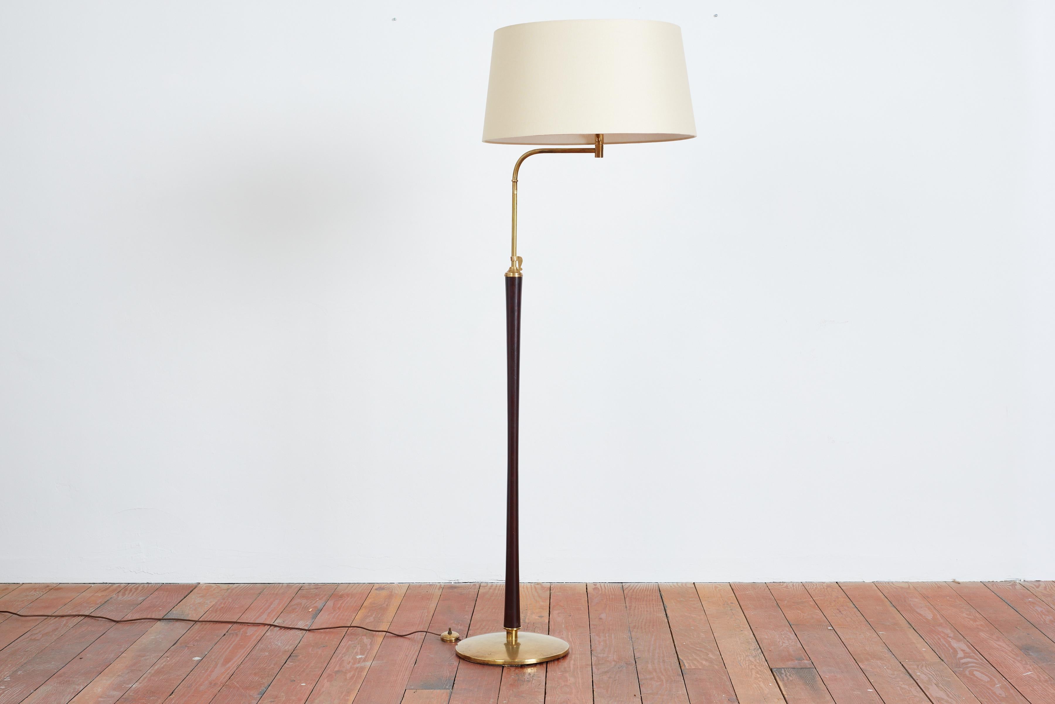 Italian mahogany floor lamp in the style of Arredoluce 
Articulating brass neck with joint that extends the reach of the arm. 
Brass base and mahogany stem with wonderful patina
New silk shade. 
Italy, 1950s

