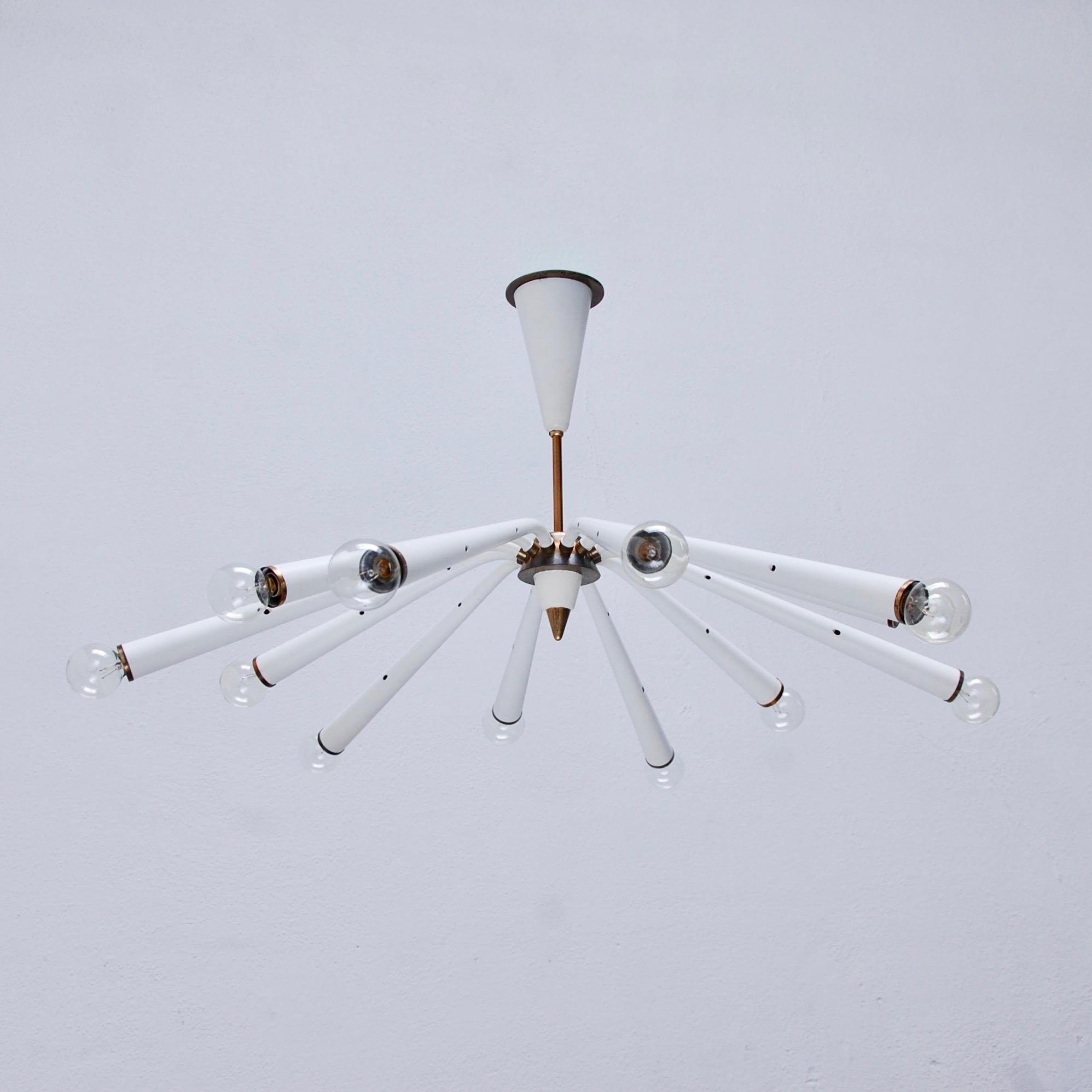 Elegant white and brass fluted Arredoluce chandelier from midcentury Italy. 12 E12 light sockets illuminate from staggered fluted arm configuration. Partially restored, original finish, fully rewired for the US. Light bulbs included with order.