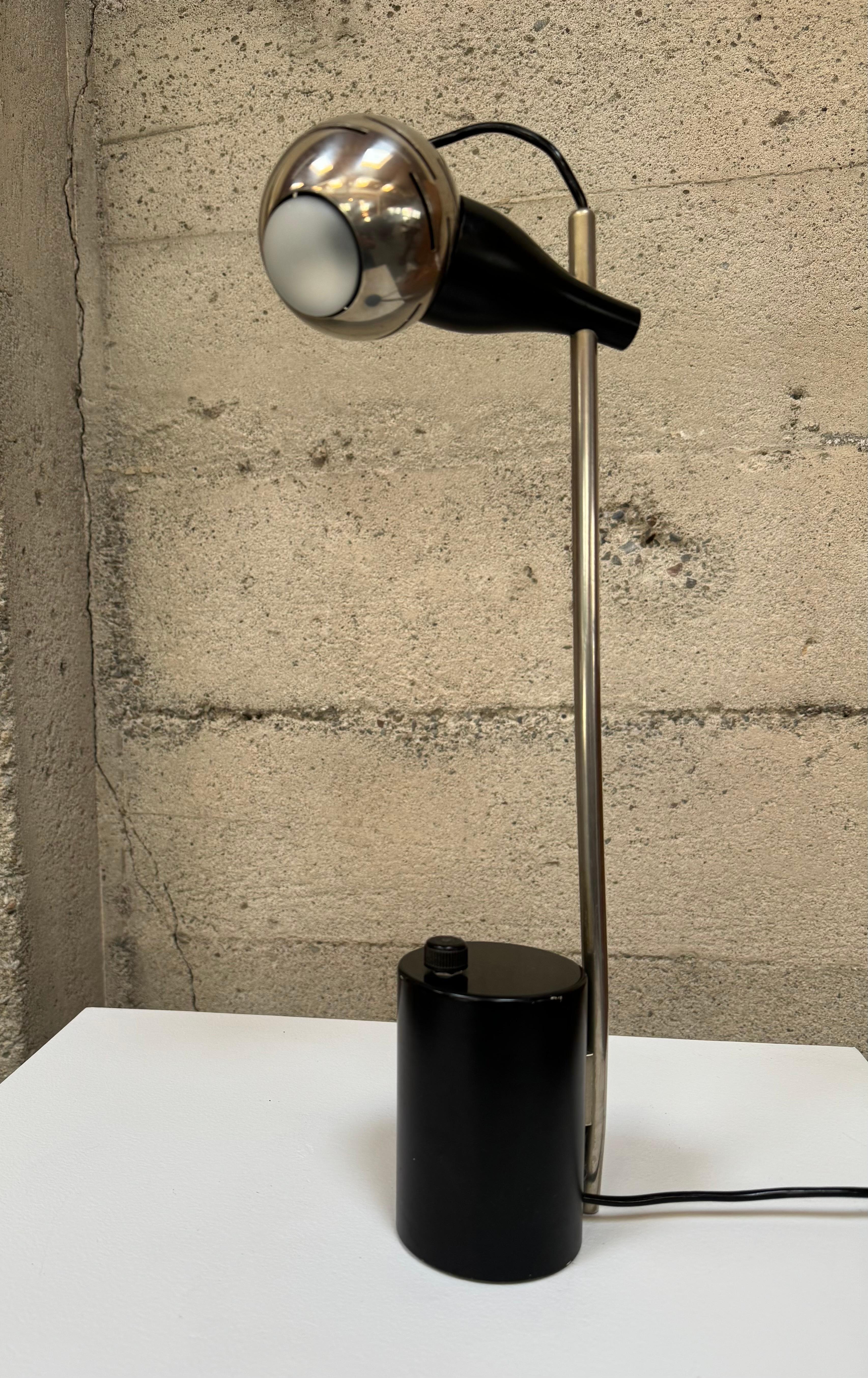 Arredoluce table lamp by Angelo Lelii circa 1963 sometimes referred to as the eye ball lamp. The lamp has a slender stem and a cylindrical base which leads into the top of lamp 