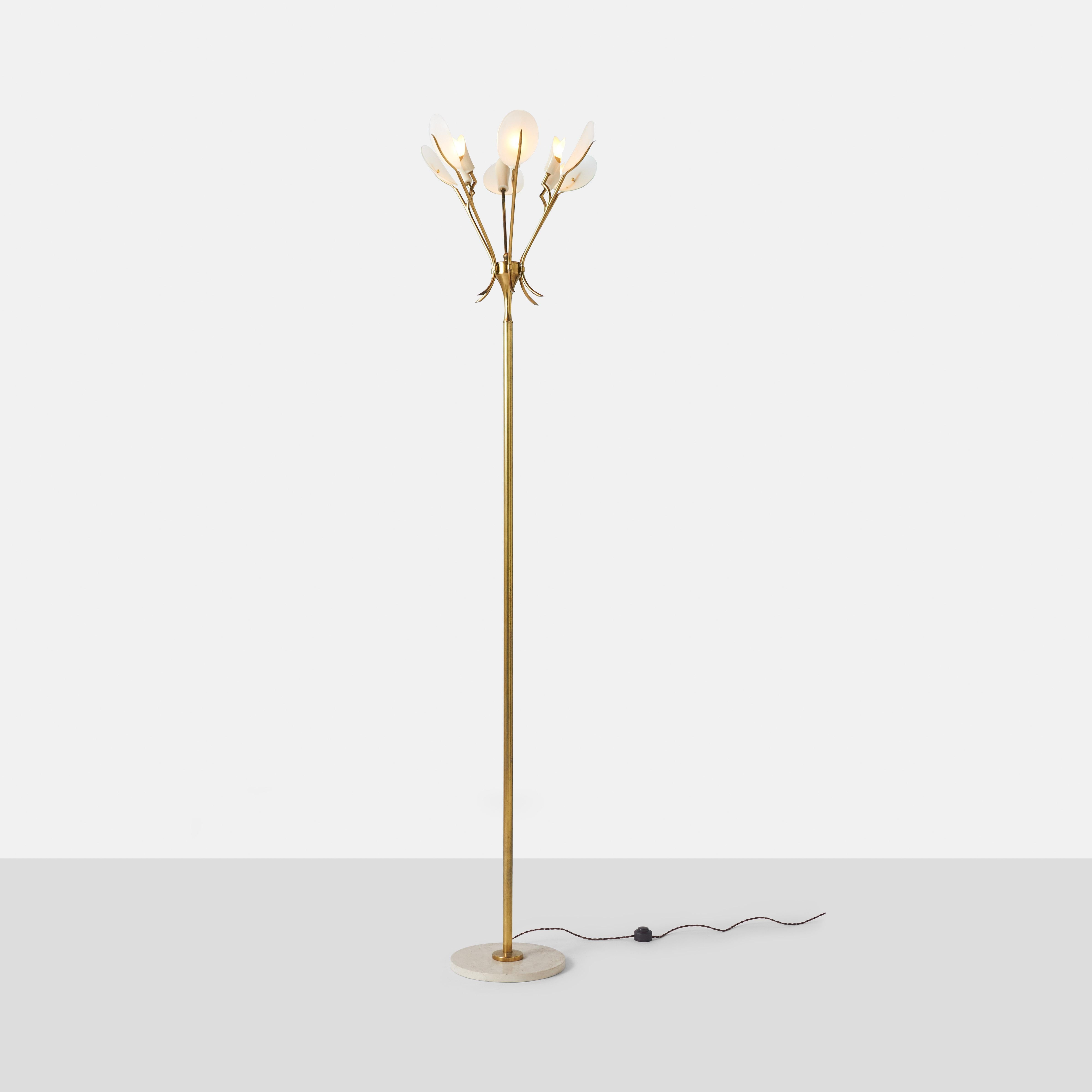 A tall floor lamp made by Arredoluce with brass arms and a travertine base.
Attached frosted glass shrouds curve gently around the bulbs.