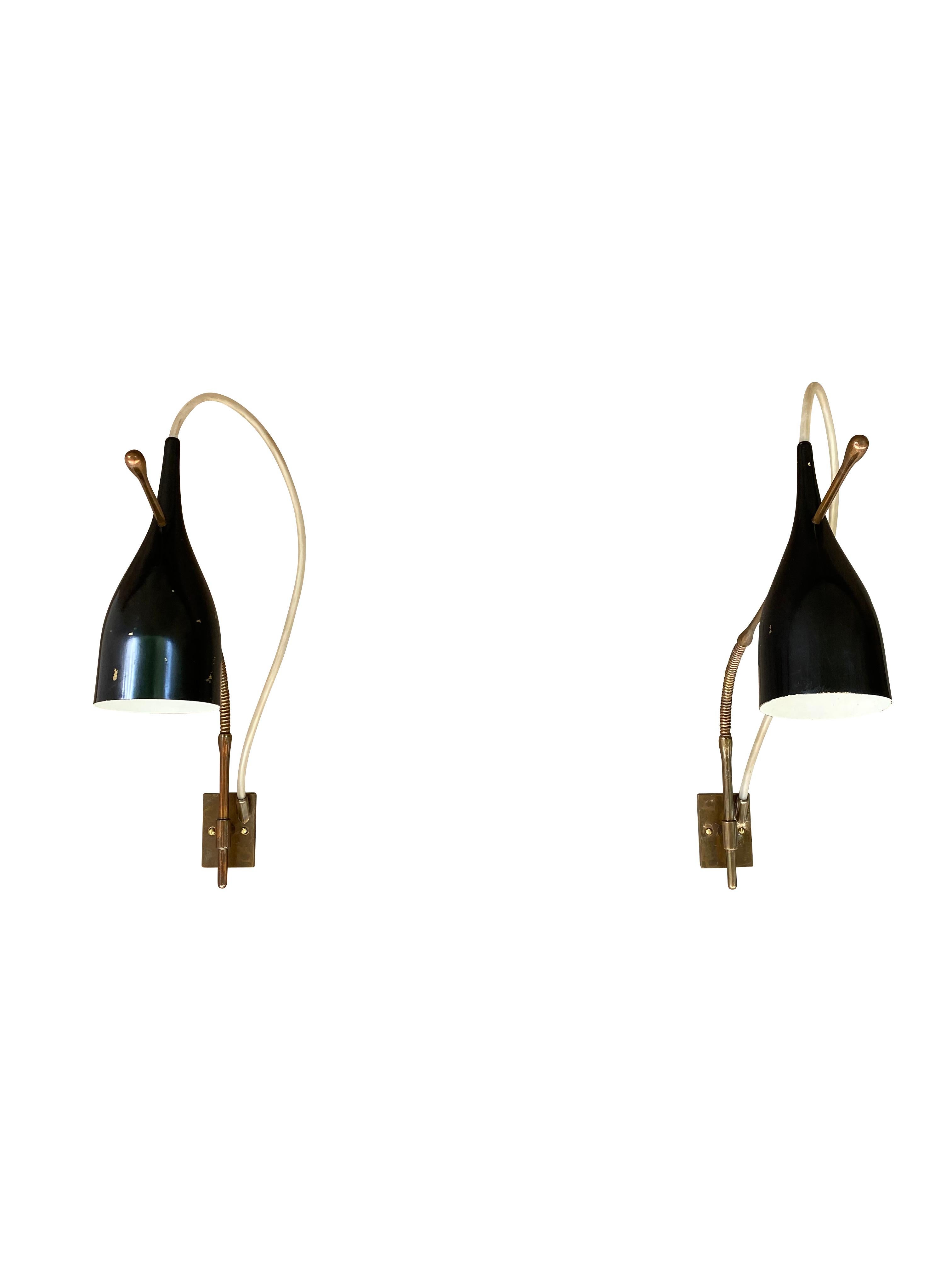 Rare wall sconce, Lucinella model number 14140, by Angelo Lelii (Lelli) for his company, Arredoluce, 1950. 

Structure compromised of flexible stem and wall plate in brass. Visibly encased electric wire in flexible tandem. Shades are in black