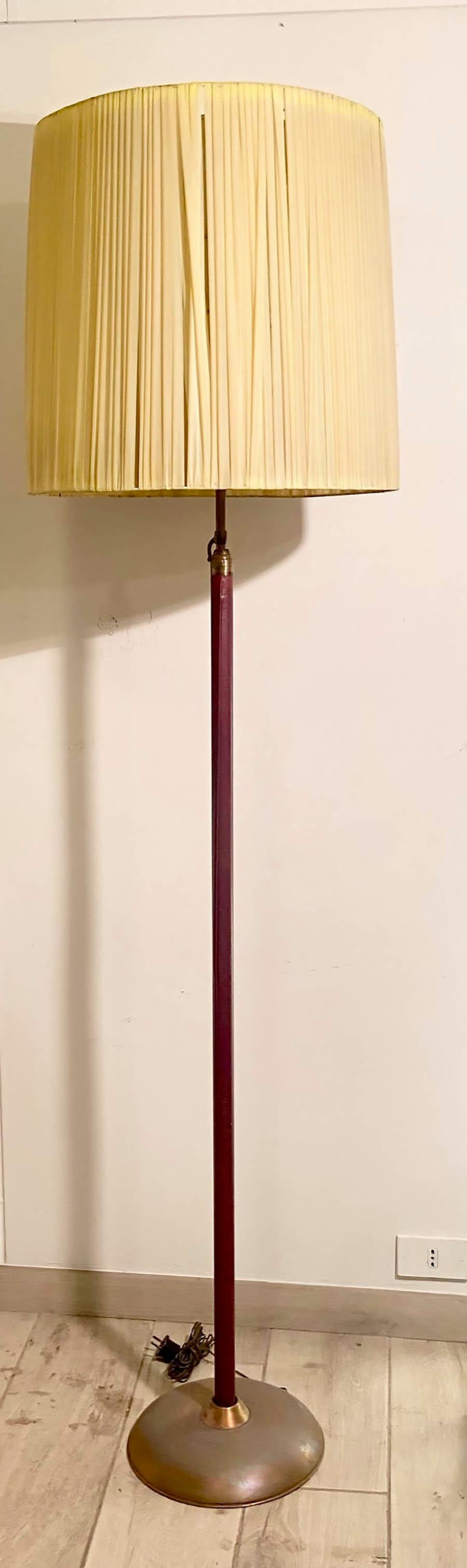 Height-adjustable floor lamp, made of brass in the style of Angelo Lelli in his productions for Arredoluce.
The raffia lampshade is not the original one, it has a maximum diameter of 50 cm.
The stem of the lamp is covered in burgundy imitation