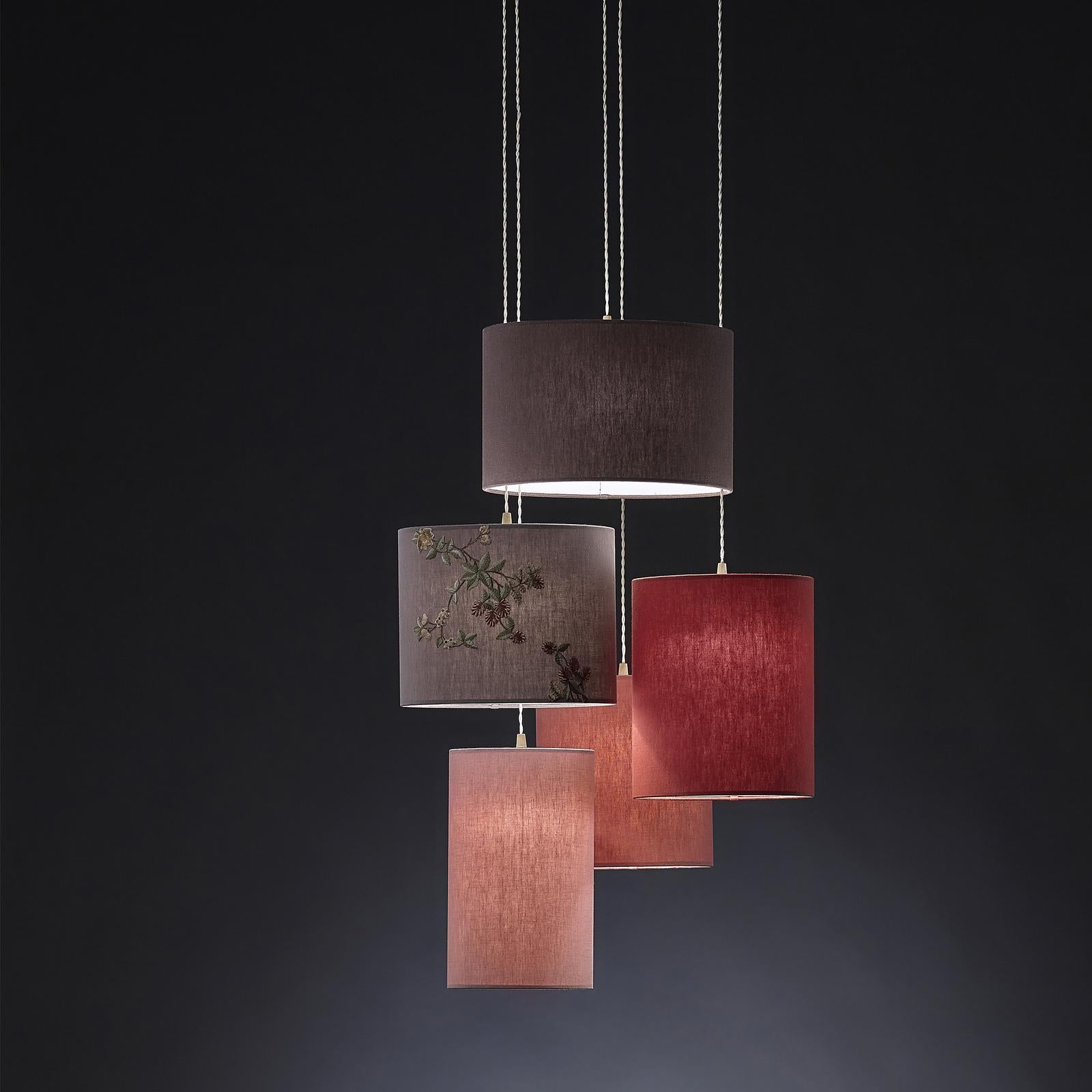 A captivating sea of red and pinks, this stunning set of pendant lamps is a harmonious display of color and shadows. Part of the Insiemi collection, the stone-wash linen drum lampshades create an elegant dance of red hues, ranging from coral pink to