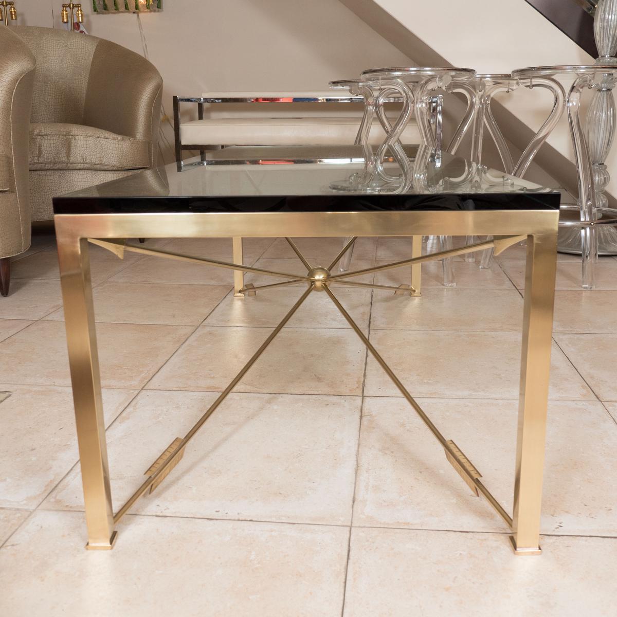 Rectangular coffee table with glass top and intersecting arrow base.