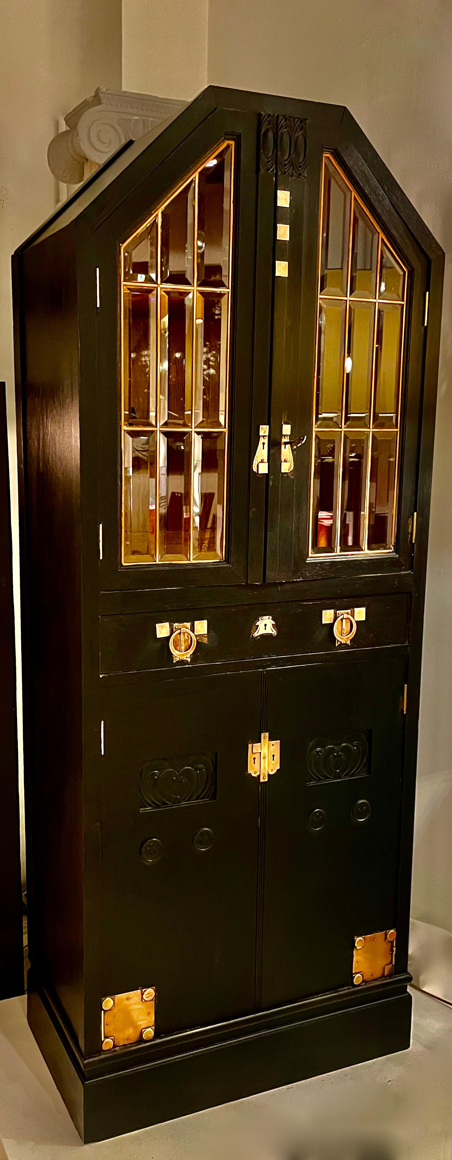 Armadio in rovere con finitura marrone scuro (quasi nero).
Doppie porte sul davanti con vetri colorati smussati.
Molti bei dettagli in ottone.
Ampio cassetto, una chiave e quattro ripiani.
Probabilmente  Belgio 