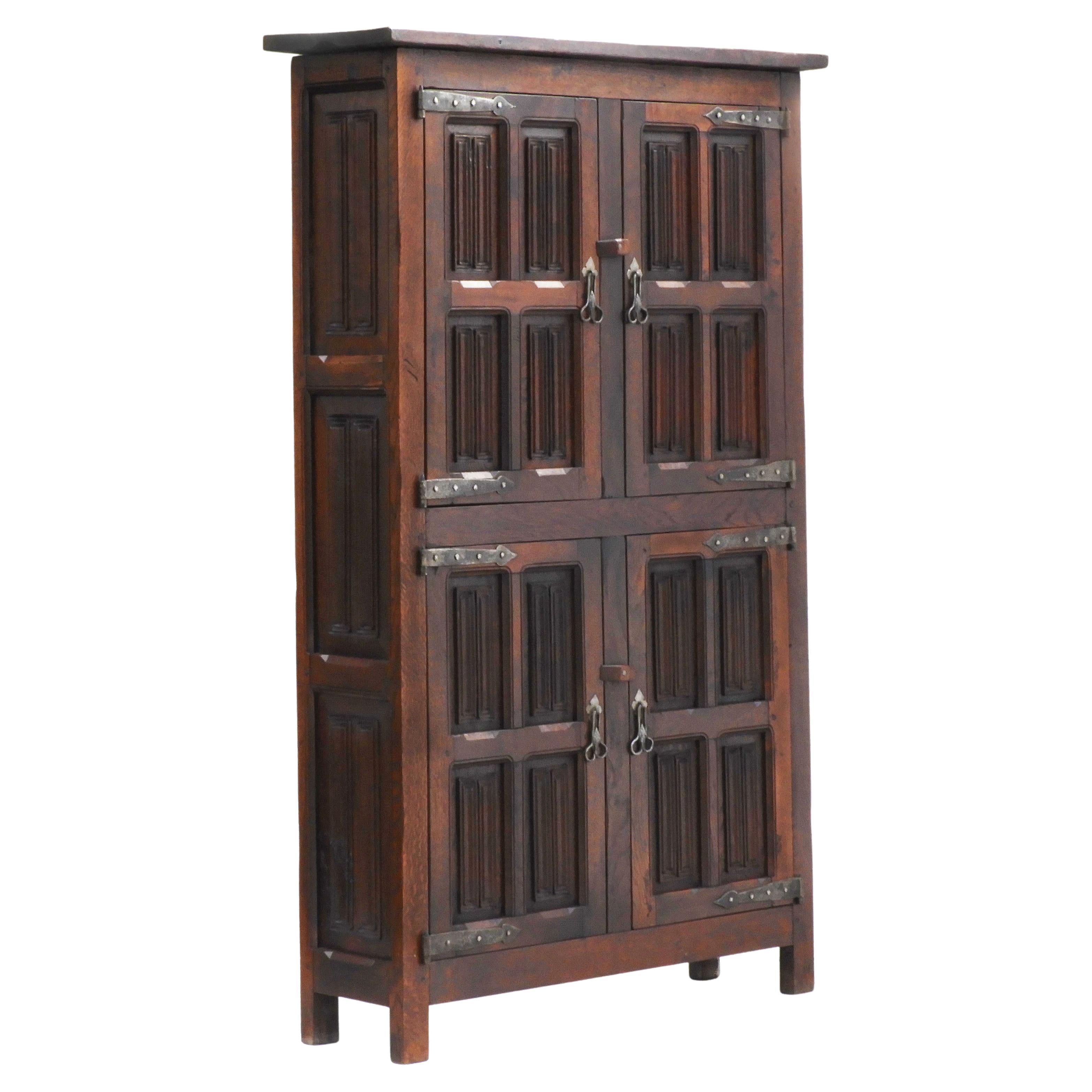 Beautiful English Arts & Crafts cupboard c1900.

A single-piece, four-door, two cupboard, linen press with wonderfully carved oak panels in Tudor revival linenfold design and finished with charming hand-forged ironmongery furnishings. A generously