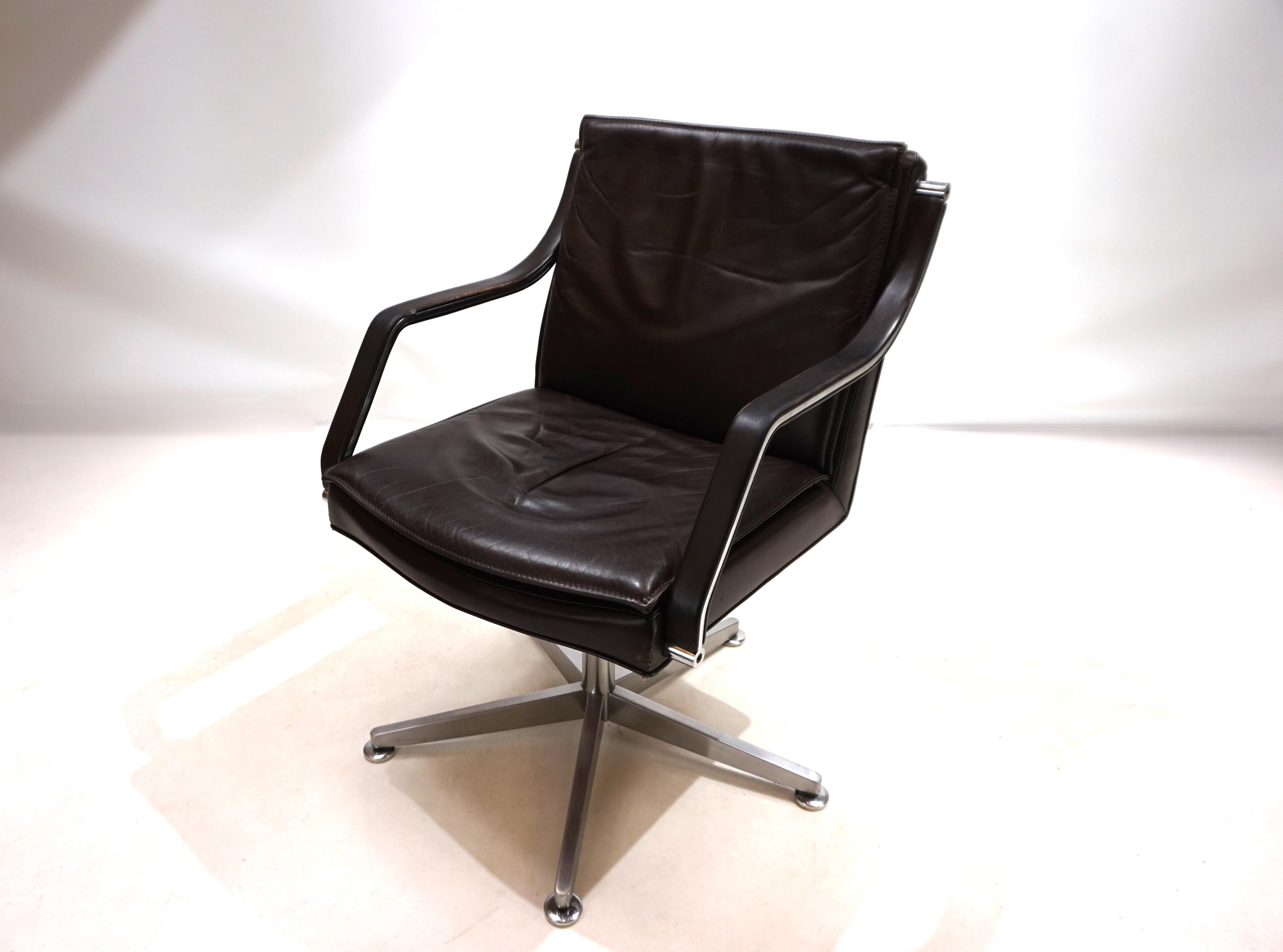 This Art Collection swivel chair comes in dark brown leather with heavy stainless steel star feet. The armrests of the chair are also made of heavy stainless steel which has been finished with leather pads. The leather of the chair shows partial