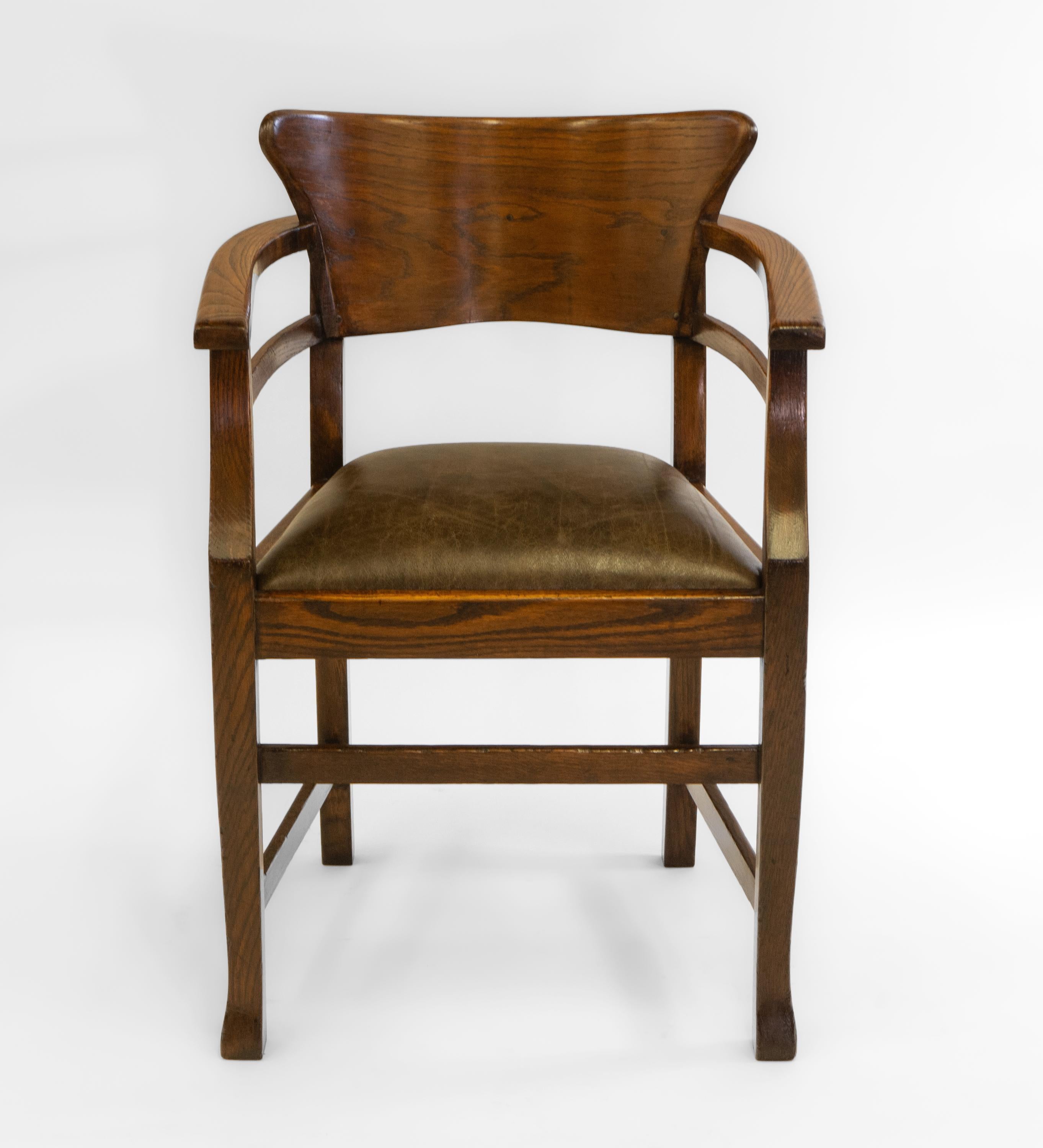Arts & Crafts oak and leather desk chair, Jugendstil, in the Richard Riemerschmid manner. Retailer's label: Solomon Bros, London. Circa 1900. 

The chair has a continuous arm around the peg constructed shaped back. The drop-in seat has been