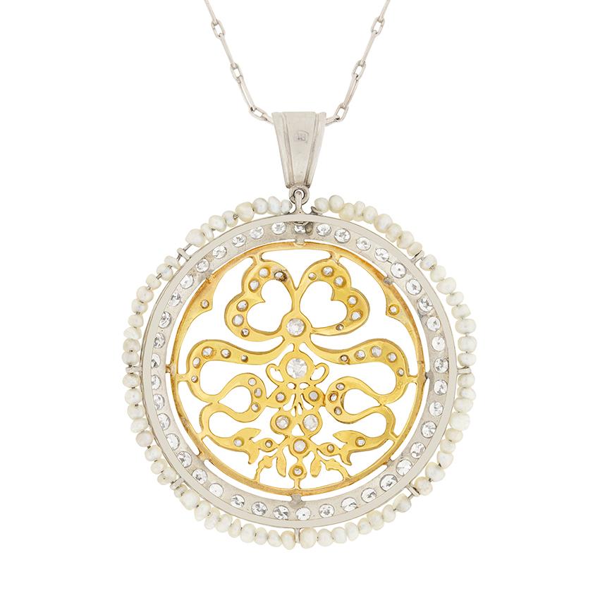 This feminine necklace was created in 1920s and features an intricate bow-like pattern studded with diamonds. The centre old cut diamond is 0.15 carat, while the rest of the pattern features 0.42 carat of rose cut diamonds. This is encircled by two