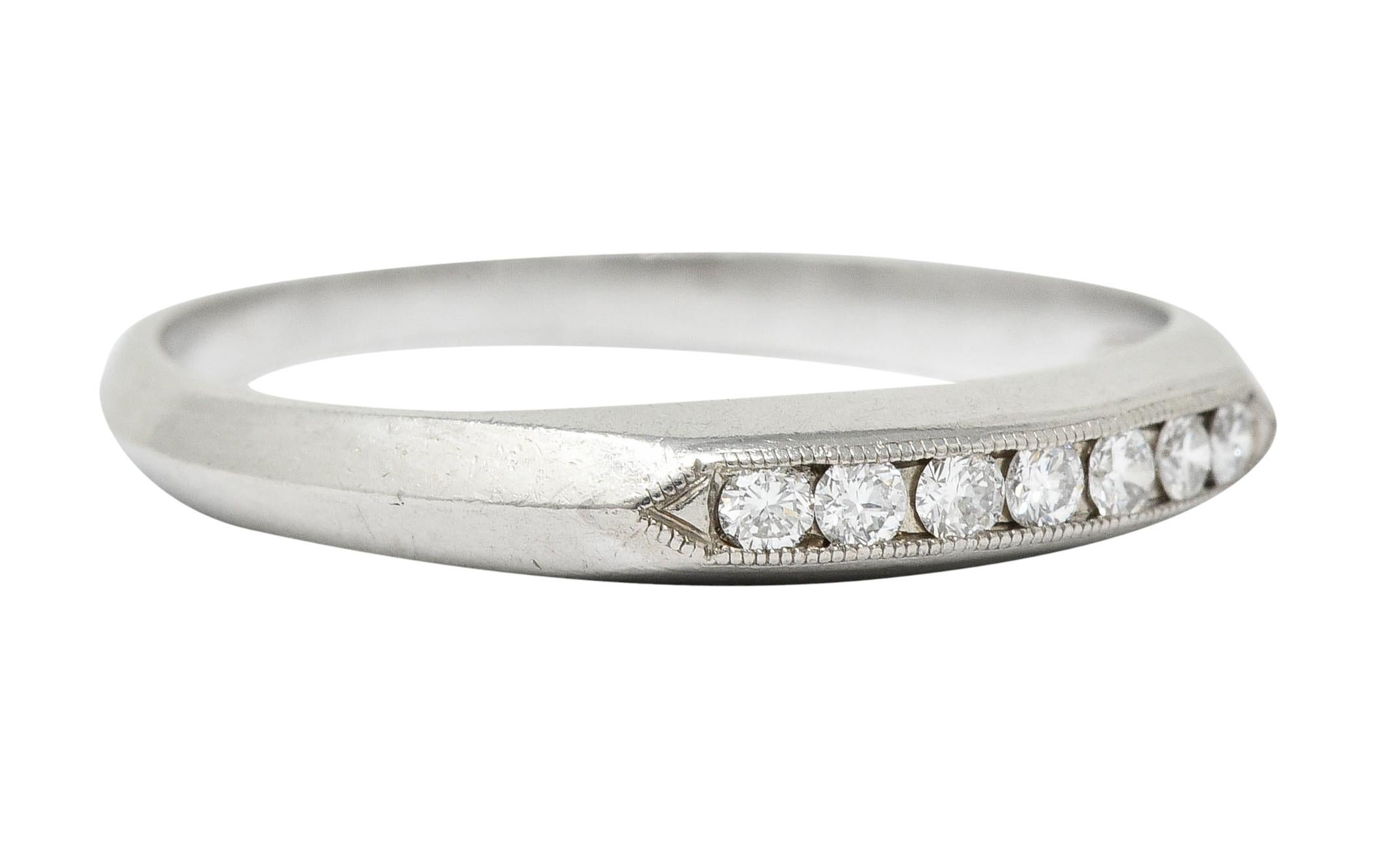 Band ring channel set to front with round brilliant cut diamonds

Weighing in total approximately 0.18 carat; eye-clean and white

Completed by milgrain, pointed shoulders, and a knife edge shank

Stamped for platinum

Circa: 1930s

Ring Size: 6 1/4