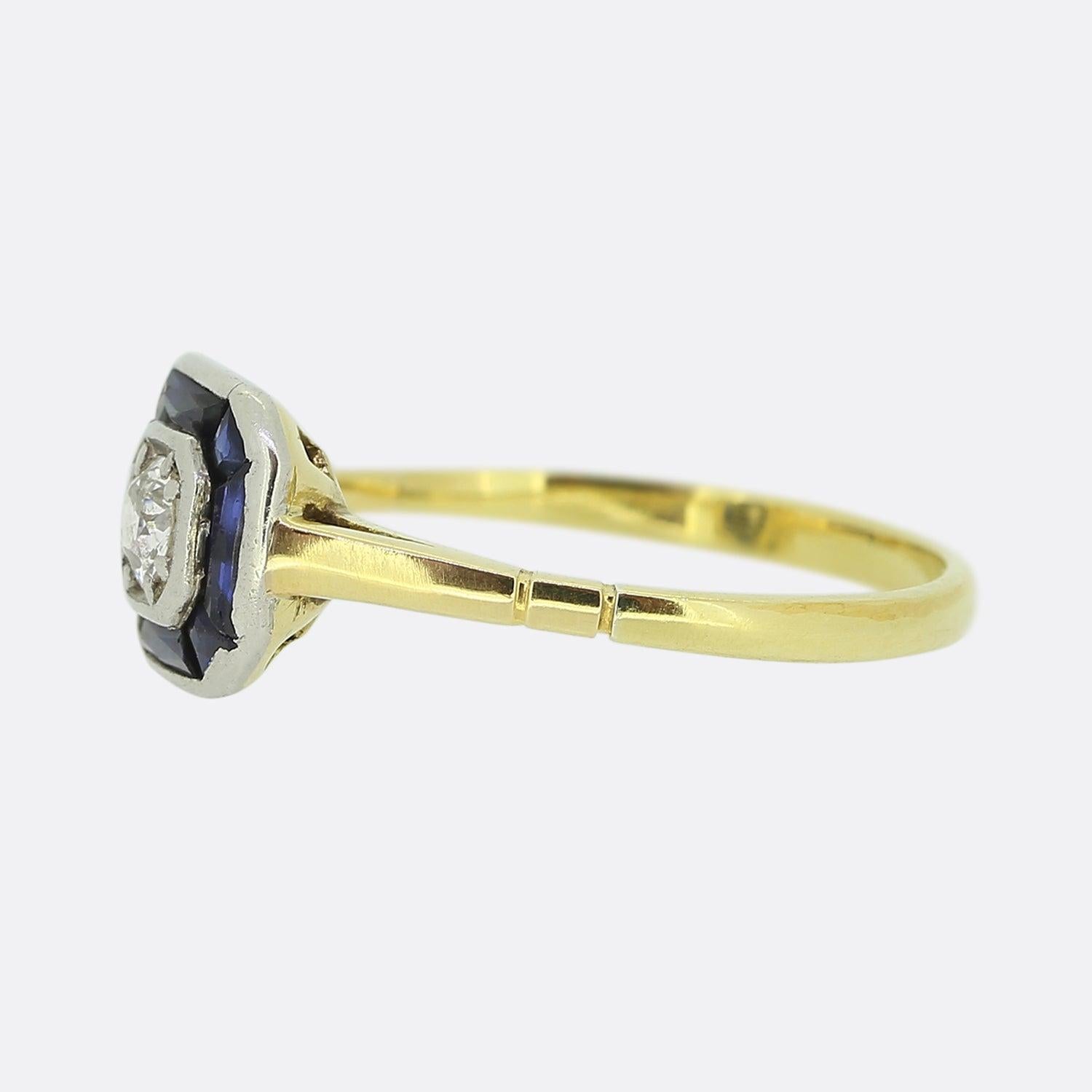 Here we have a delightful piece from a time when the Art Deco style was at the height of design. A single round faceted old cut diamond sits slightly risen at the centre of the face and is framed by a single row of calibrated sapphires possessing a