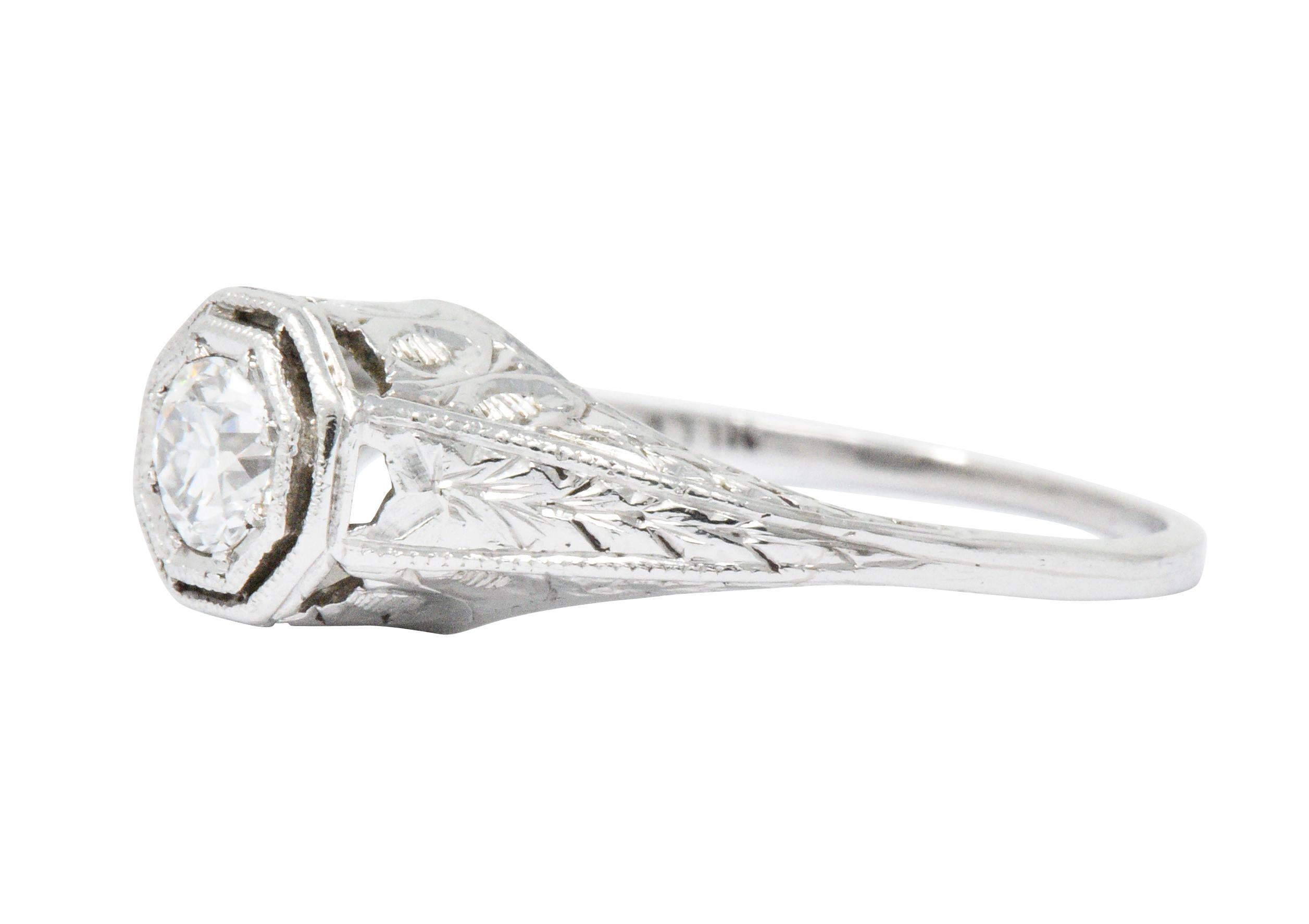 Centering an old European cut diamond weighing approximately 0.25 carat, H color with SI clarity

Set low in a Octagonal head flanked by engraved foliate shoulders

With unique geometric motif profile details

Tested as platinum

Circa: 1930s

Ring