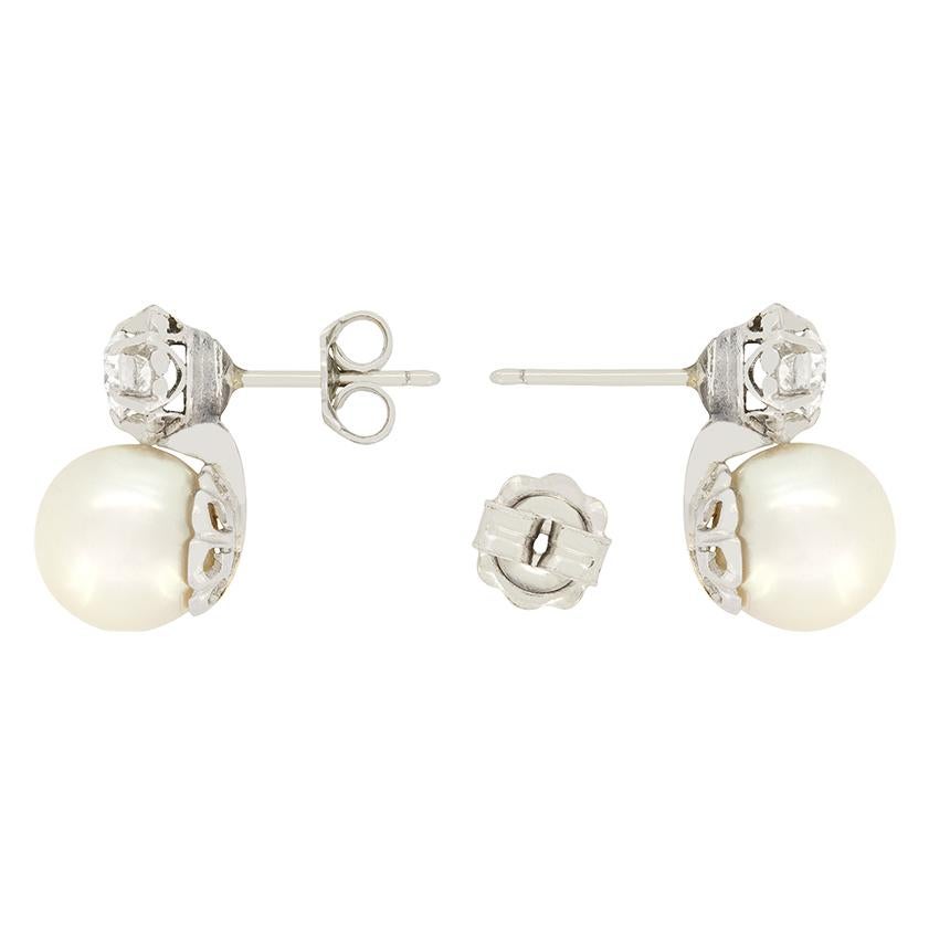 Beautifully Art Deco, this wonderful pair of earrings feature a top old cut diamond with a pearl hanging below. Each diamond has been expertly claw set into the platinum mounts, they weigh 0.30 carat each and have both been graded H to I in colour