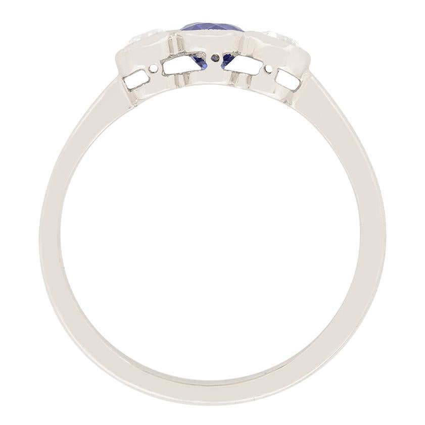 This lovely sapphire and diamond ring is from the art deco era. A deep blue sapphire sits in the centre, it is old cut and is 0.35 carat. Two old cut diamonds sit on either side of the sapphire, and are 0.25 carat each. They add a bit of sparkling