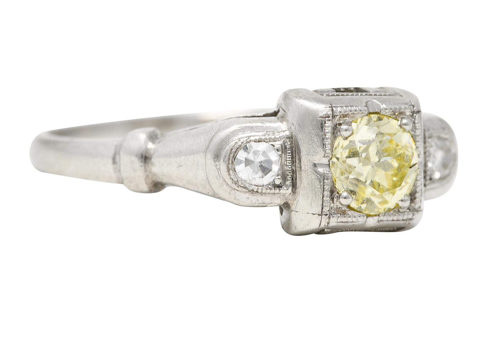 Featuring a fancy colored old European cut diamond weighing approximately 0.30 carat. Fancy light yellow in color with SI1 clarity. Set low in a square form head and flanked by half moon formed cathedral shoulders. Accented by single cut diamonds