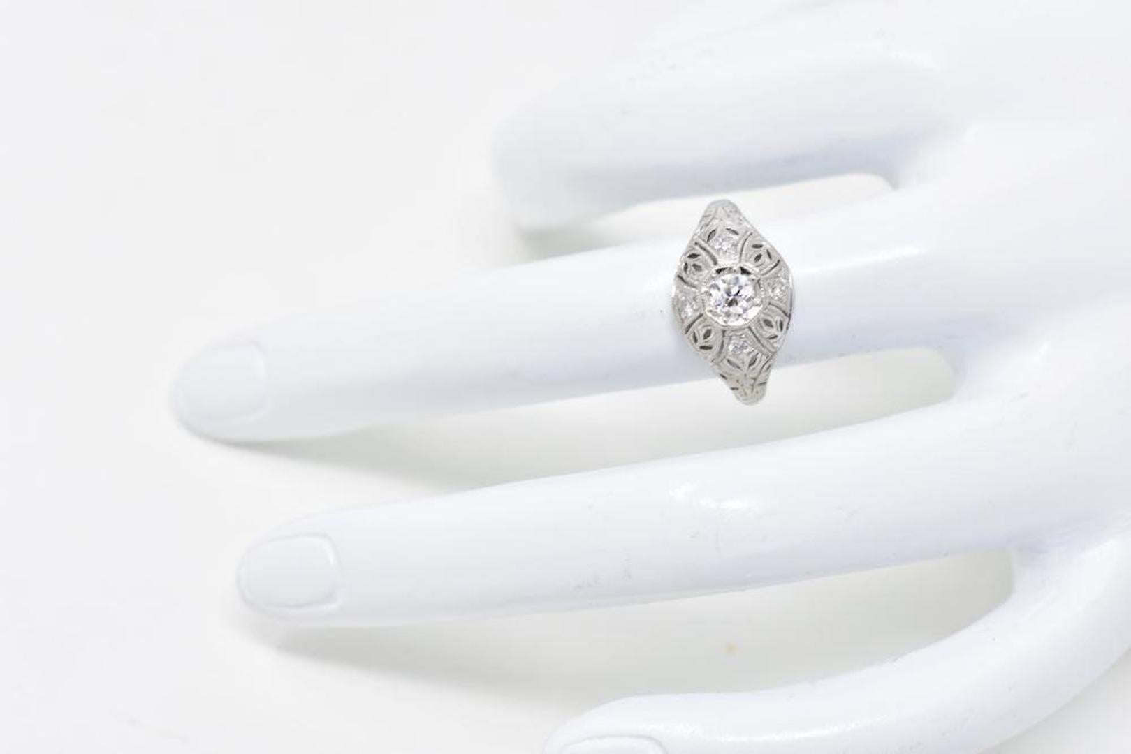 Lovely Art Deco 18K white gold engagement ring. Centering an old European cut diamond weighing approximately 0.30 carats, F color and VS clarity. The mounting is decorated in a lovely symmetric filigree Art Deco design. Delicately placed in the