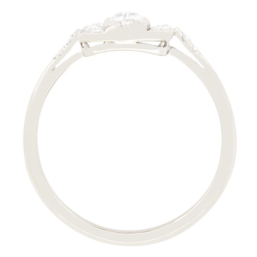 Questo sorprendente anello Art Deco con diamante a grappolo presenta al centro un diamante antico da 0,40 carati con taglio a marquise. Il diamante, incastonato a sfregamento, ha un colore F e una purezza VS1. La pietra centrale è circondata da