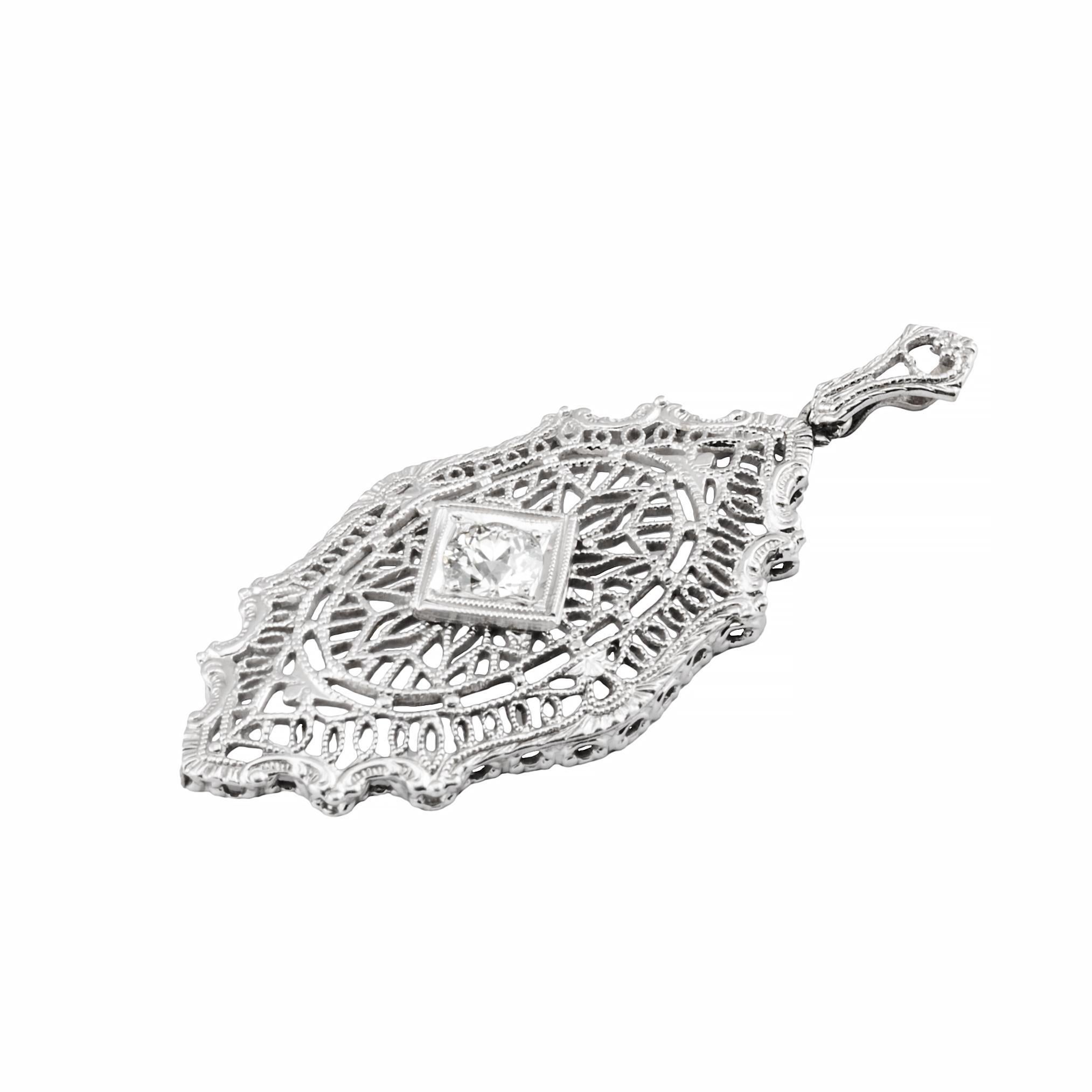 Aston Estate Jewelry Presents:

An exquisite diamond pendant in white gold. Featuring an intricate filigree design with a central European cut diamond weighing 0.4 carats. The diamond is of H color and VS2 clarity, set within a delicate lattice of