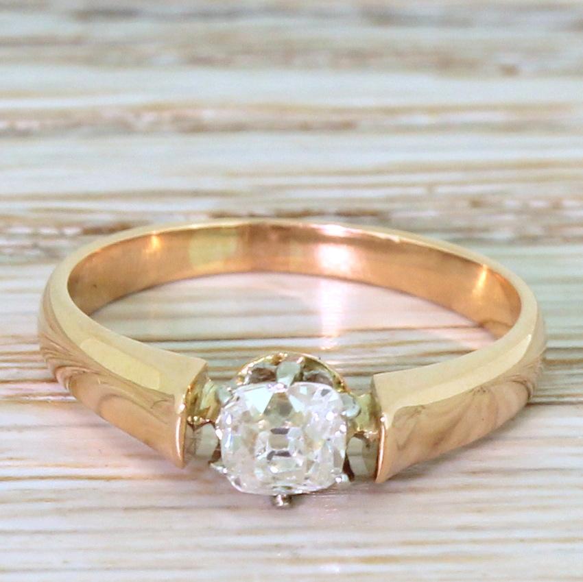 An antique diamond ring that just aches with character. The imperfectly shaped (and deep) old mine cut diamond is high white and very clean – and is secured in a six claw white gold collet which sits almost within a chunky, high shouldered 18k rose