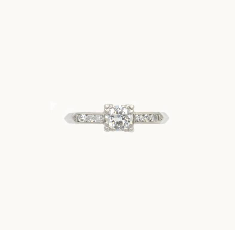 Art Deco vintage diamond and platinum engagement ring from circa 1940s. This pretty ring features a 0.50 carat transitional round diamond that is H-I in color and VS2 in clarity. The center diamond is set in a four bead square setting with 6 single