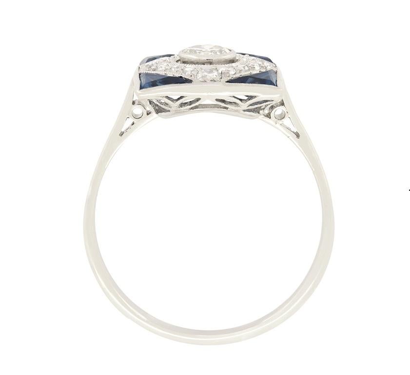 Dieser quadratische Art-Déco-Ring strahlt den Stil und das Design der Epoche aus. Sein Herzstück ist ein altgeschliffener Diamant mit einem Gewicht von 0,40 Karat, der mit einer Reibefassung versehen ist. Er ist von weiteren 0,40 Karat Diamanten im
