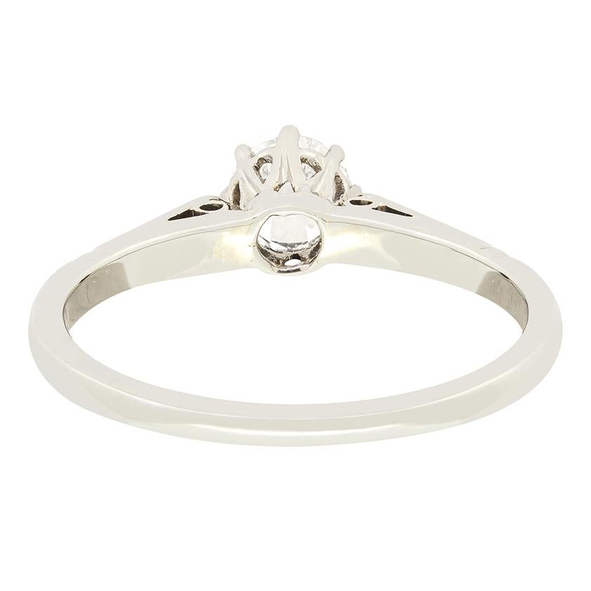 Ce magnifique solitaire antique date des années 1920. Un diamant taille ancienne de 0,50 carat brille en son centre, serti dans un collier en platine. Le diamant a une couleur H et une pureté VS22. Le long de chaque épaule, des motifs sculptés