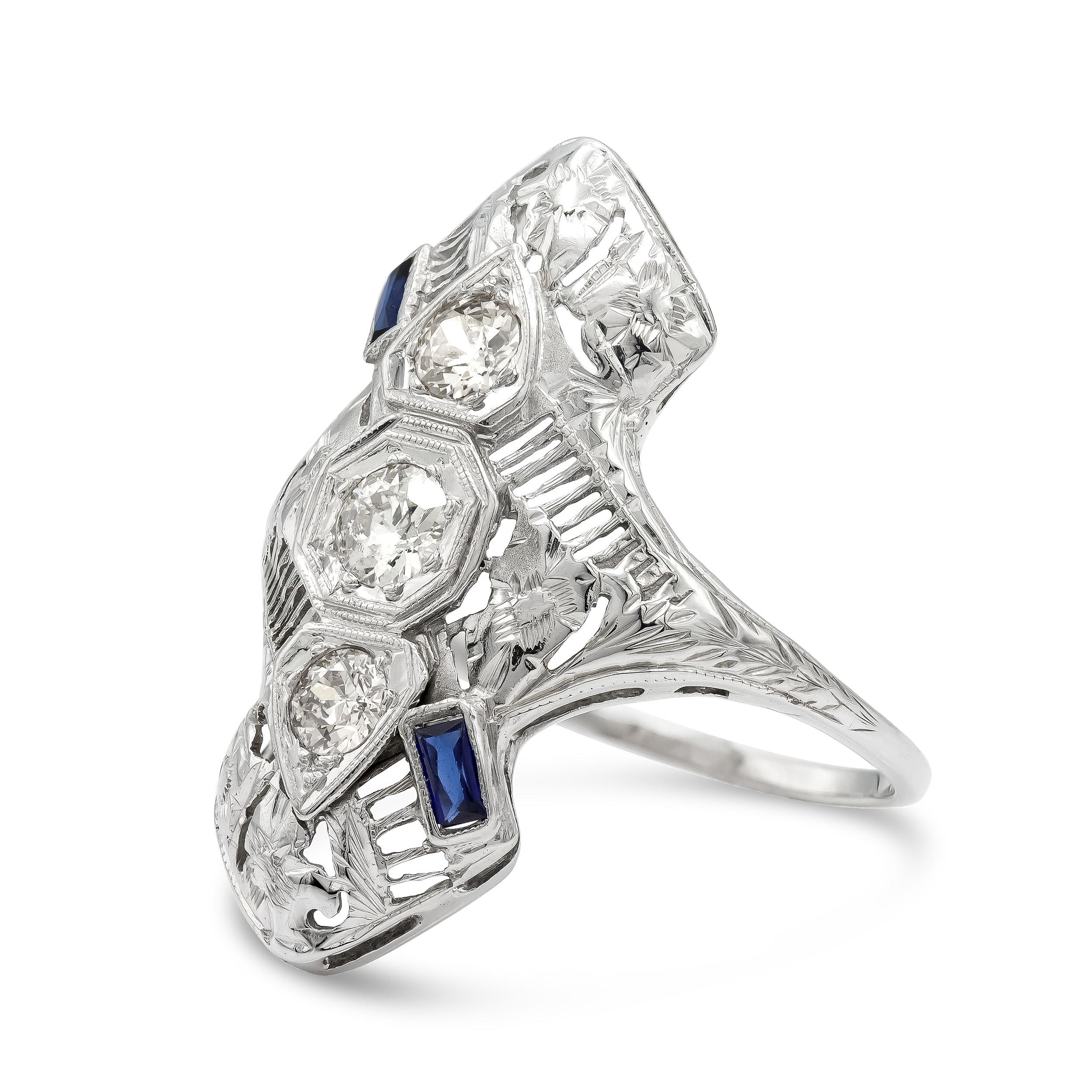 Here's a twist on a trilogy ring you didn't know you needed. Three old European cut diamonds weighing just over 0.50 carats are fashioned in this unique pointed setting. The unique shape paired with the two french cut sapphires make this low profile