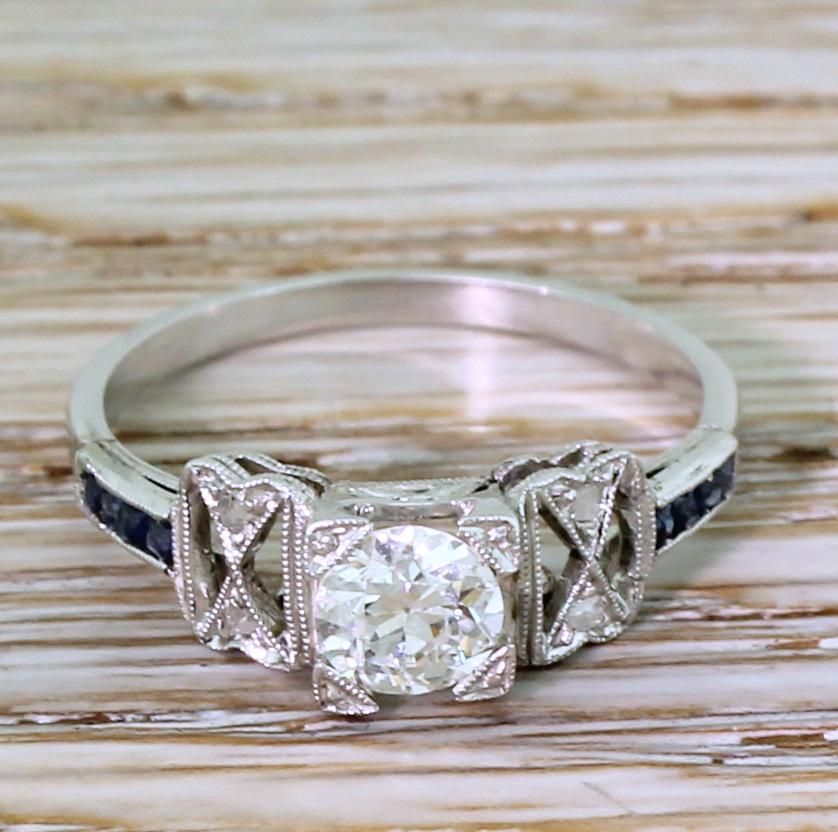 An absolutely amazing early Art Deco engagement ring. The old European cut diamond in the centre is blindingly white and bursting with life and fire. The stone is secured in a square collet with fine milgraining on the claws and in the gallery. The