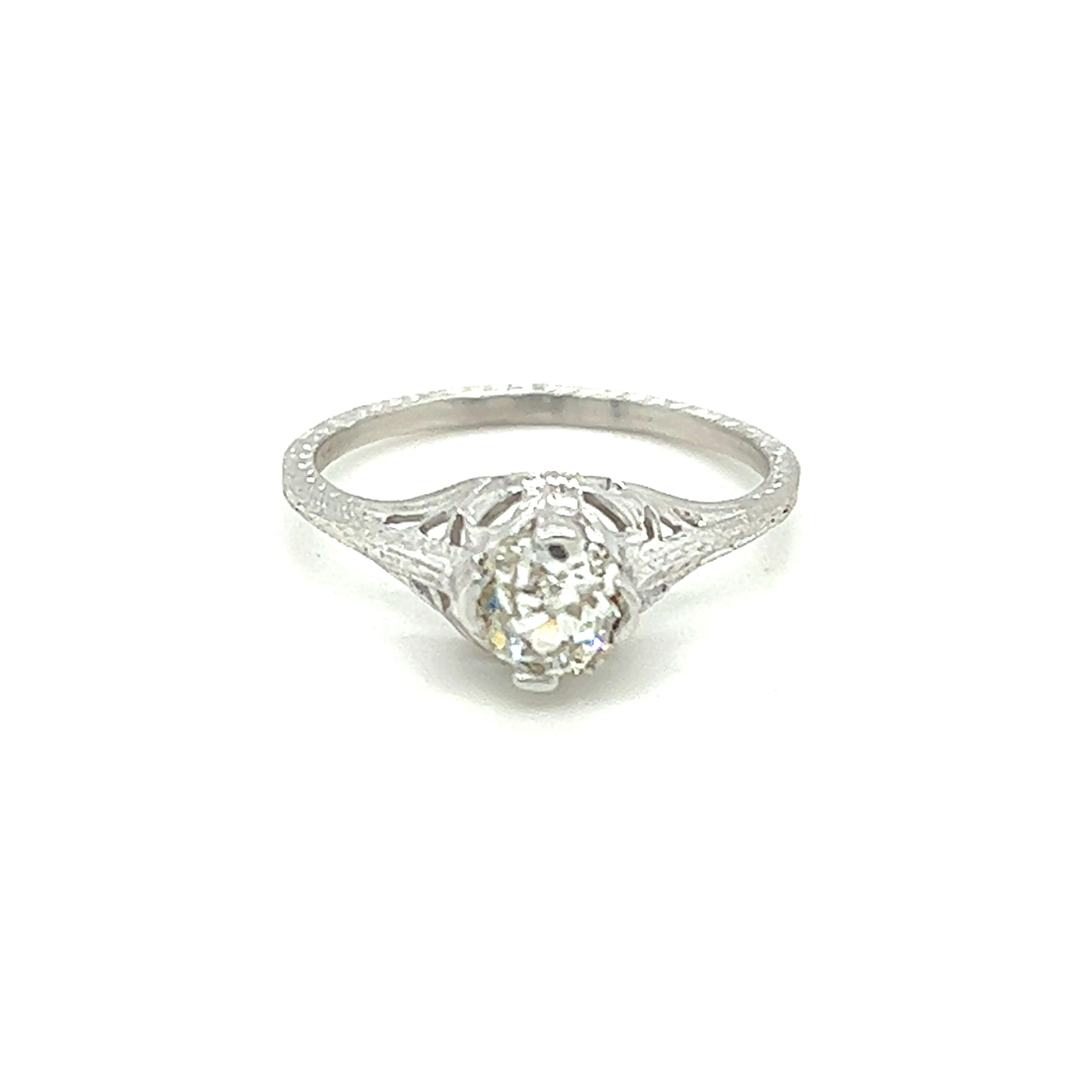 One 18 karat white gold Art Deco filigree diamond engagement ring set with one antique cushion cut diamond, approximately 0.57 carat  with K color and I1 clarity. The ring is a finger size 6.75 and can be resized. Sizing is not included.  The ring
