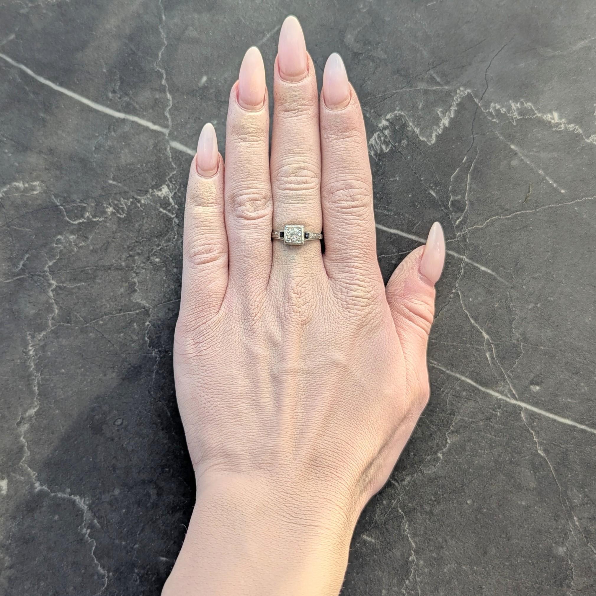 Centering an old European cut diamond weighing approximately 0.46 carat - K color with VS2 clarity
Bead set in a square form head flanked by French cut sapphires flush set in shoulders
Weighing approximately 0.14 carat total - transparent medium