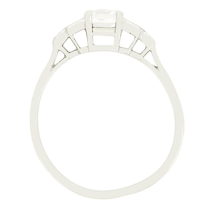 Datant des années 1920  Cette magnifique bague est un classique de l'Art déco. Un diamant baguette unique se trouve au centre, flanqué d'autres diamants baguette sur des épaules étagées. Le diamant central pèse 0,60 carat et est de haute qualité