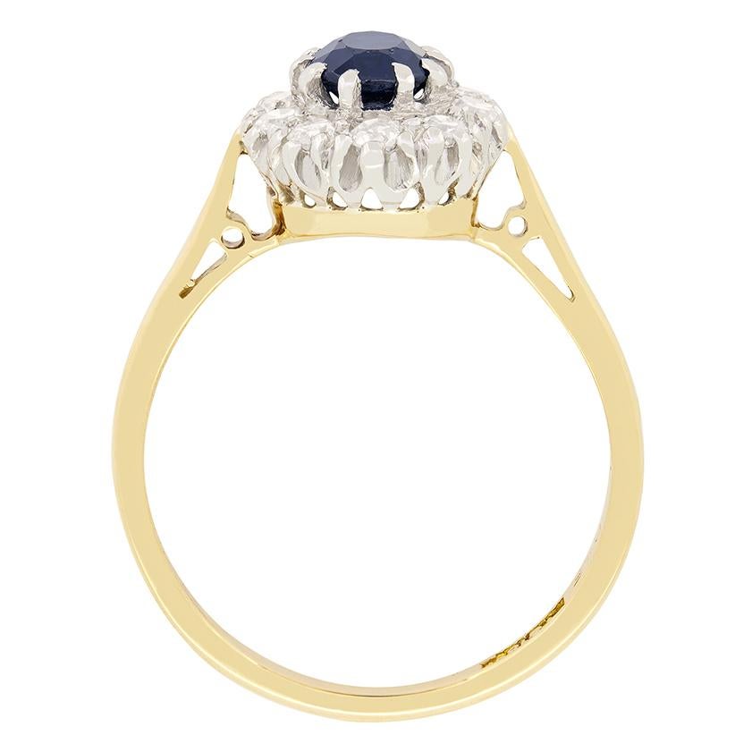 This beautiful  cluster ring dates back to the Art Deco Period. A deep blue sapphire sits at its centre, enveloped by a halo of glistening diamonds. The oval cut sapphire is an 0.60 carat and claw set into a platinum collet. The surrounding diamonds